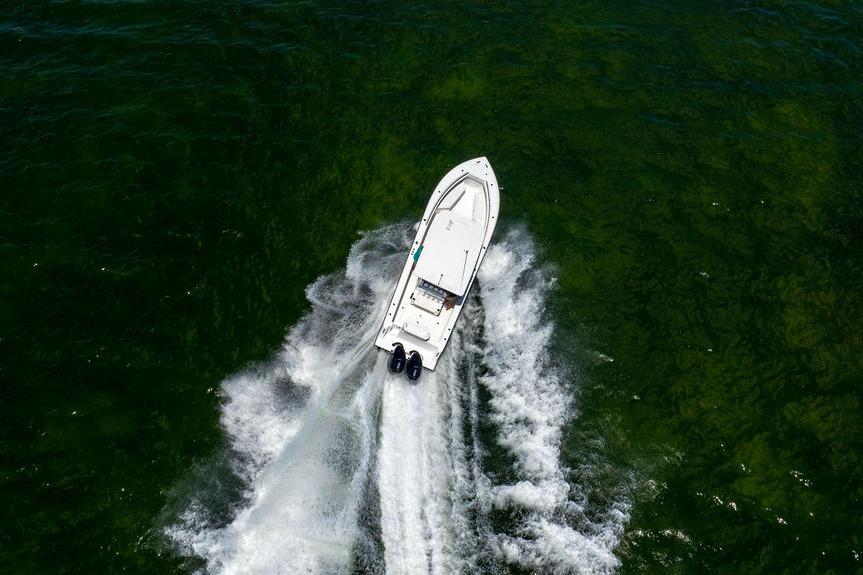 Aerial view of 2027 Reef Runner 340 boat speeding on green water.