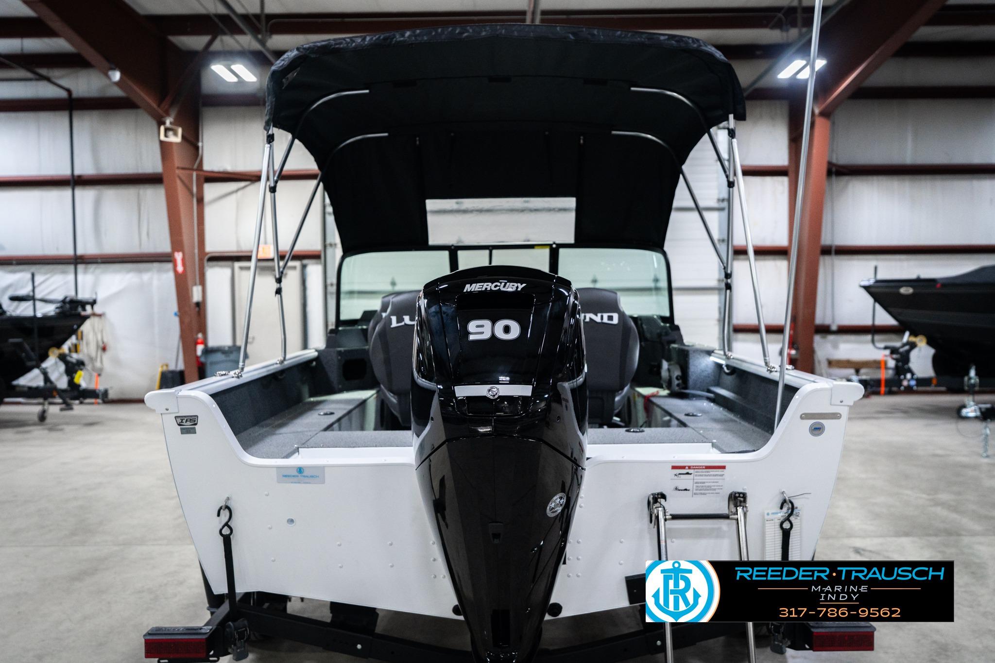 2026 Lund 1700 Explorer Sport boat with Mercury 90 engine in showroom.