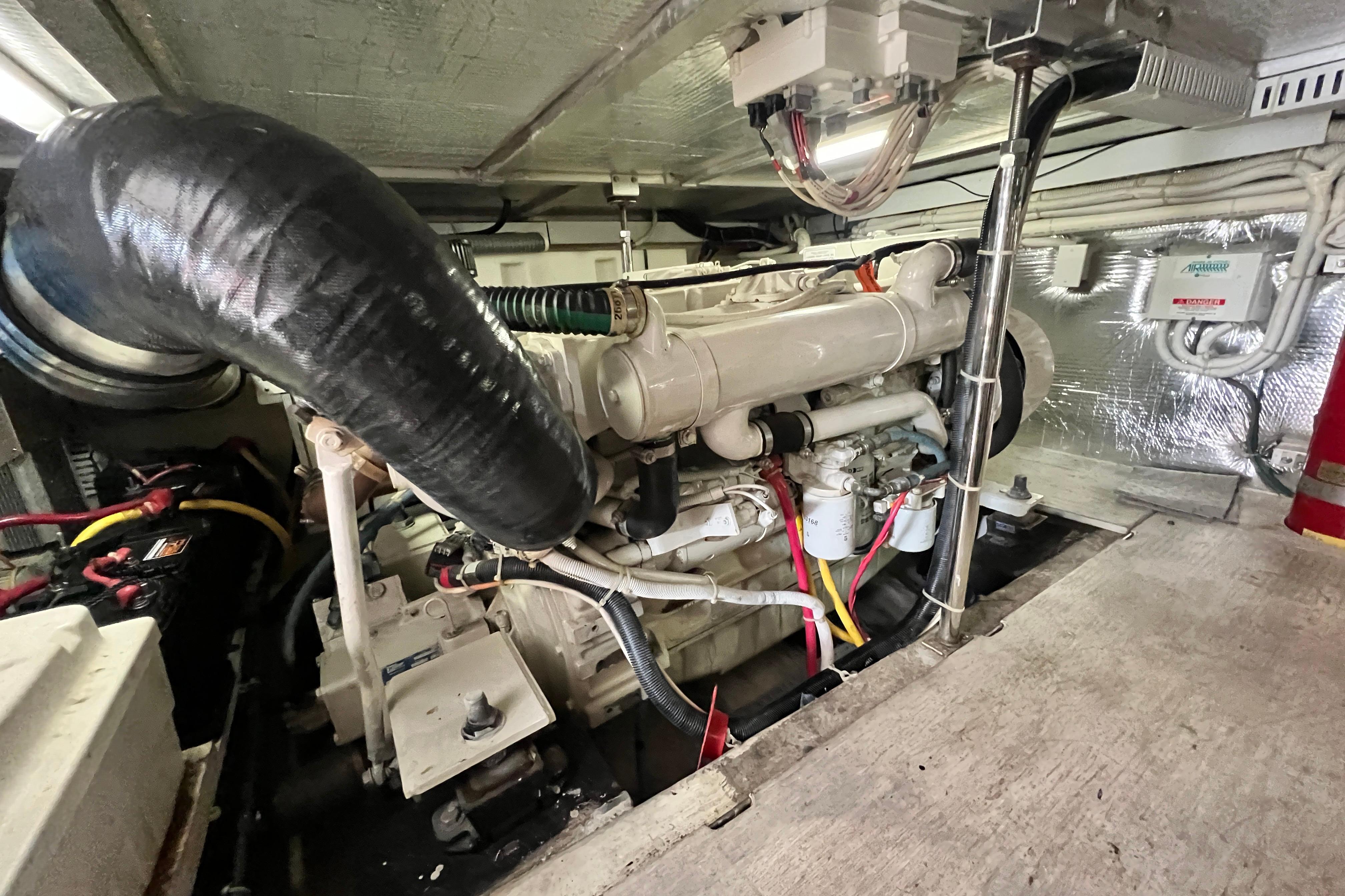 Engine room of a 2003 Carver 450 Voyager Pilothouse yacht, showcasing mechanical components.