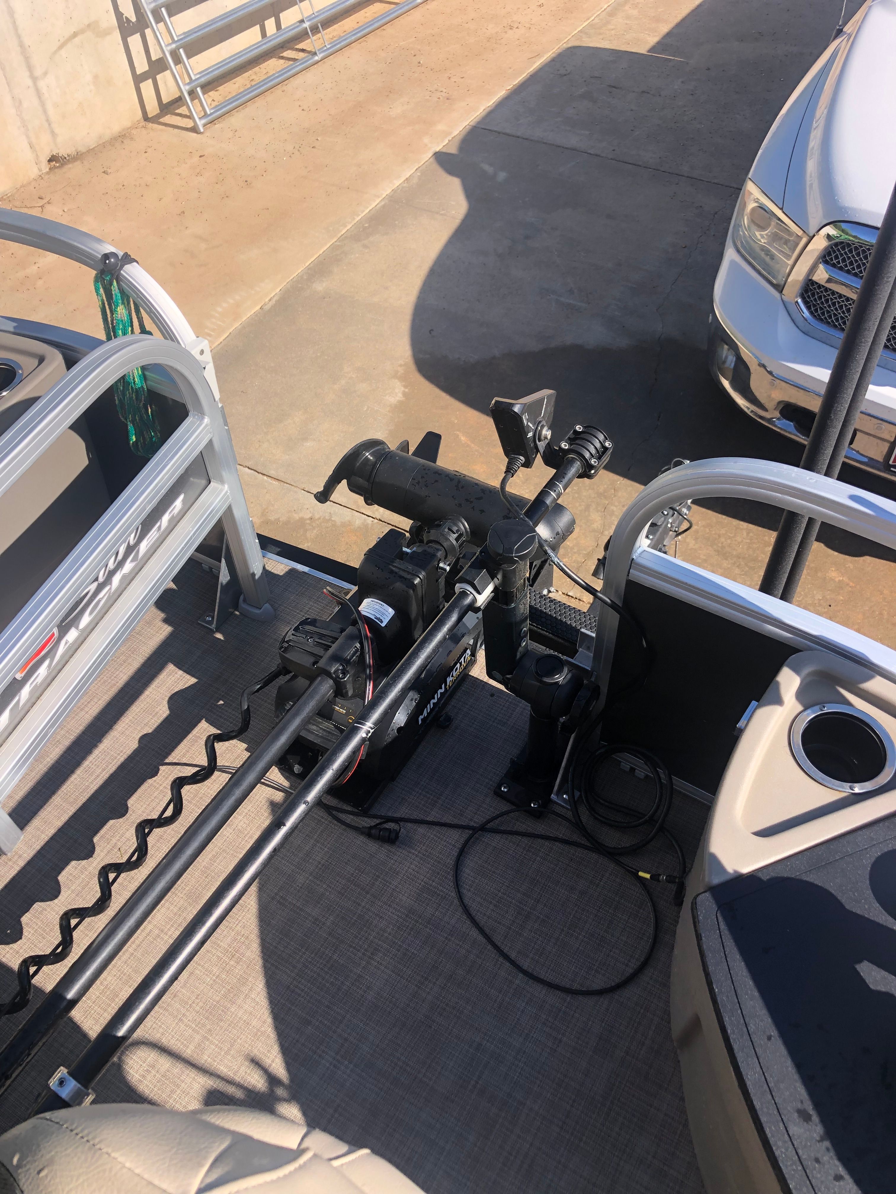 The image shows the deck of a Sun Tracker Fishin' Barge 22 DLX boat with fishing gear.