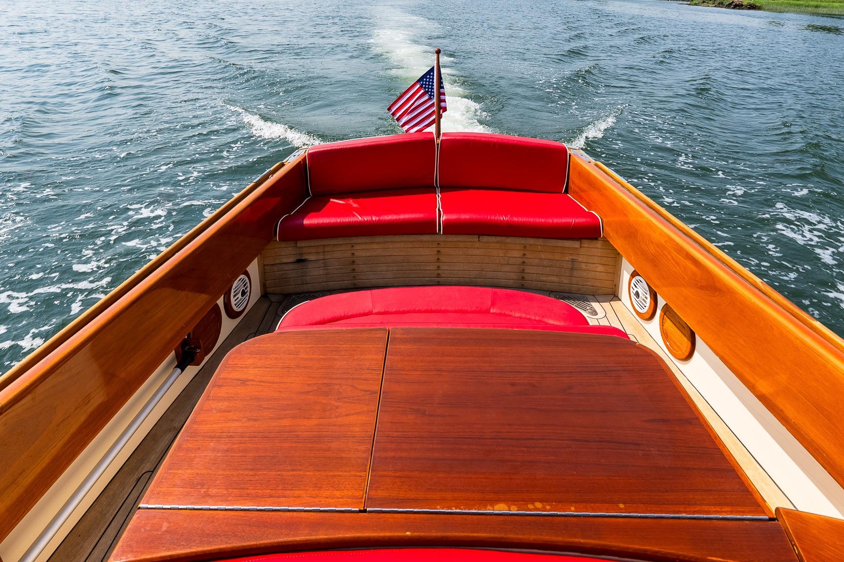 2005 Hinckley Talaria 29R boat with red seating and American flag on water.
