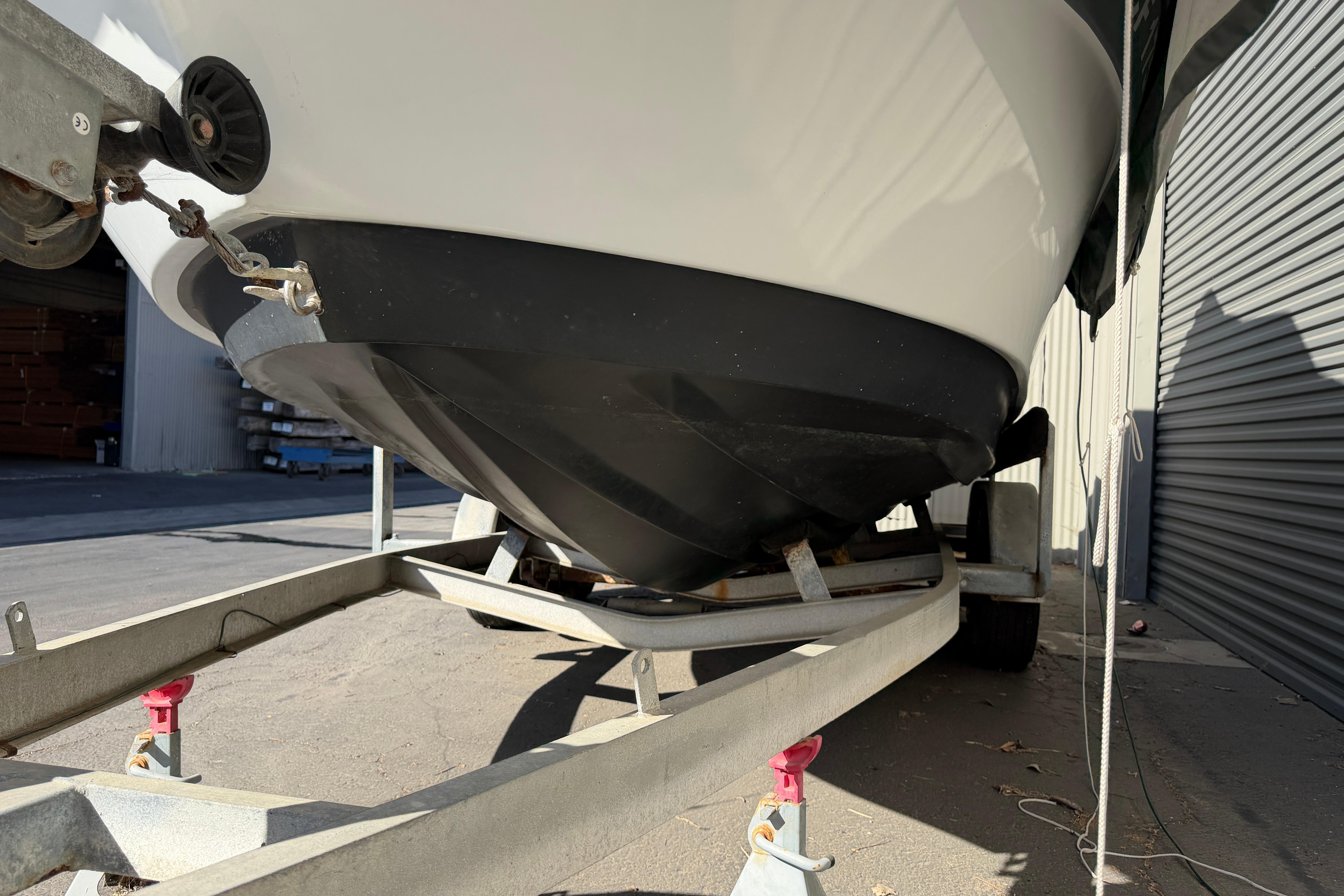1986 Radon 21 Sport boat on trailer, showing hull and bow details in a garage setting.