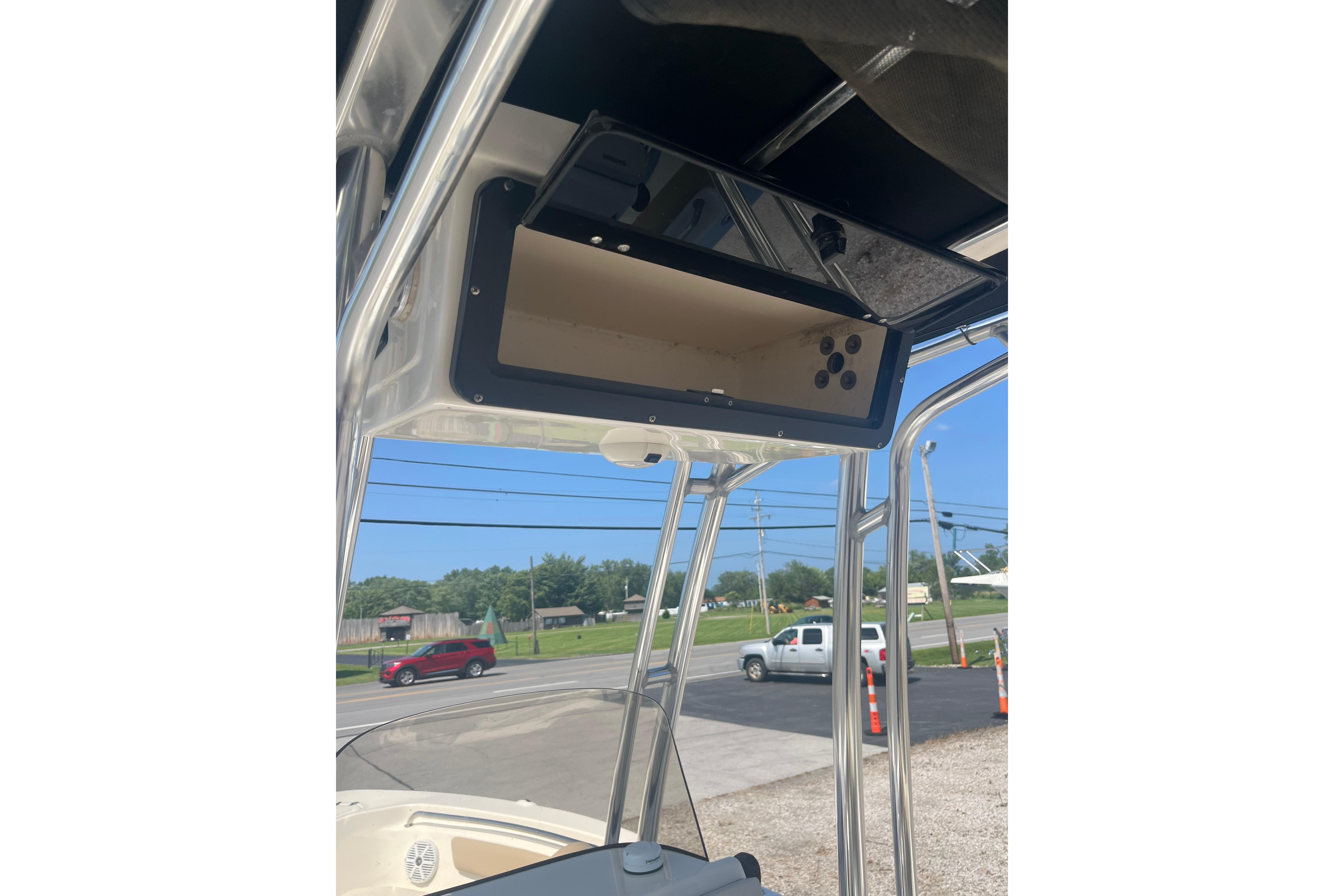 2017 Key West 203 FS boat console with overhead storage and clear blue sky background.