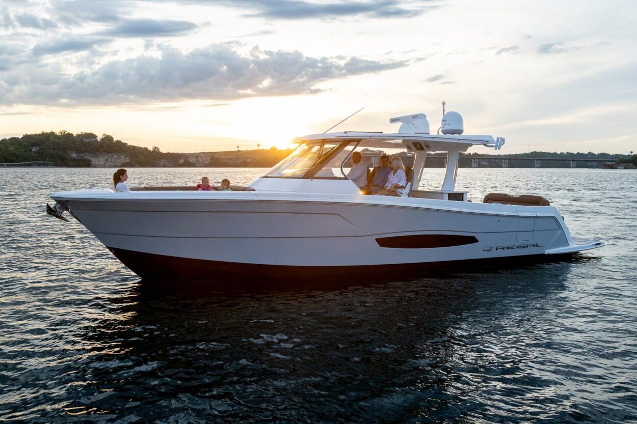 Manufacturer Provided Image: 2026 Regal 38 Surf boat cruising at sunset on a serene lake.