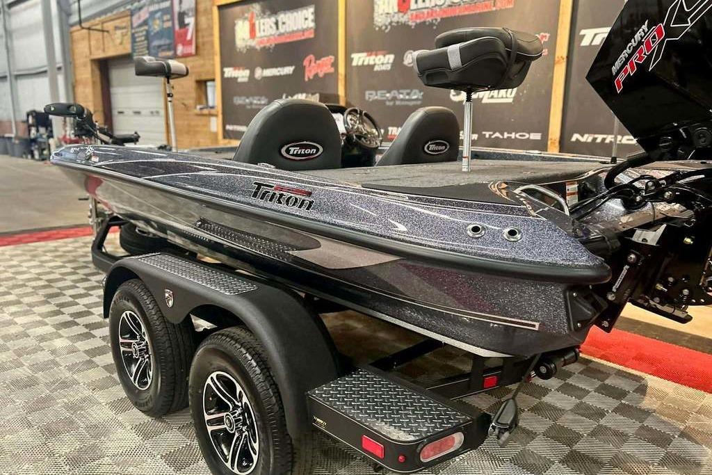 2026 Triton 18 TrX bass boat on trailer, showcased indoors with sleek design.