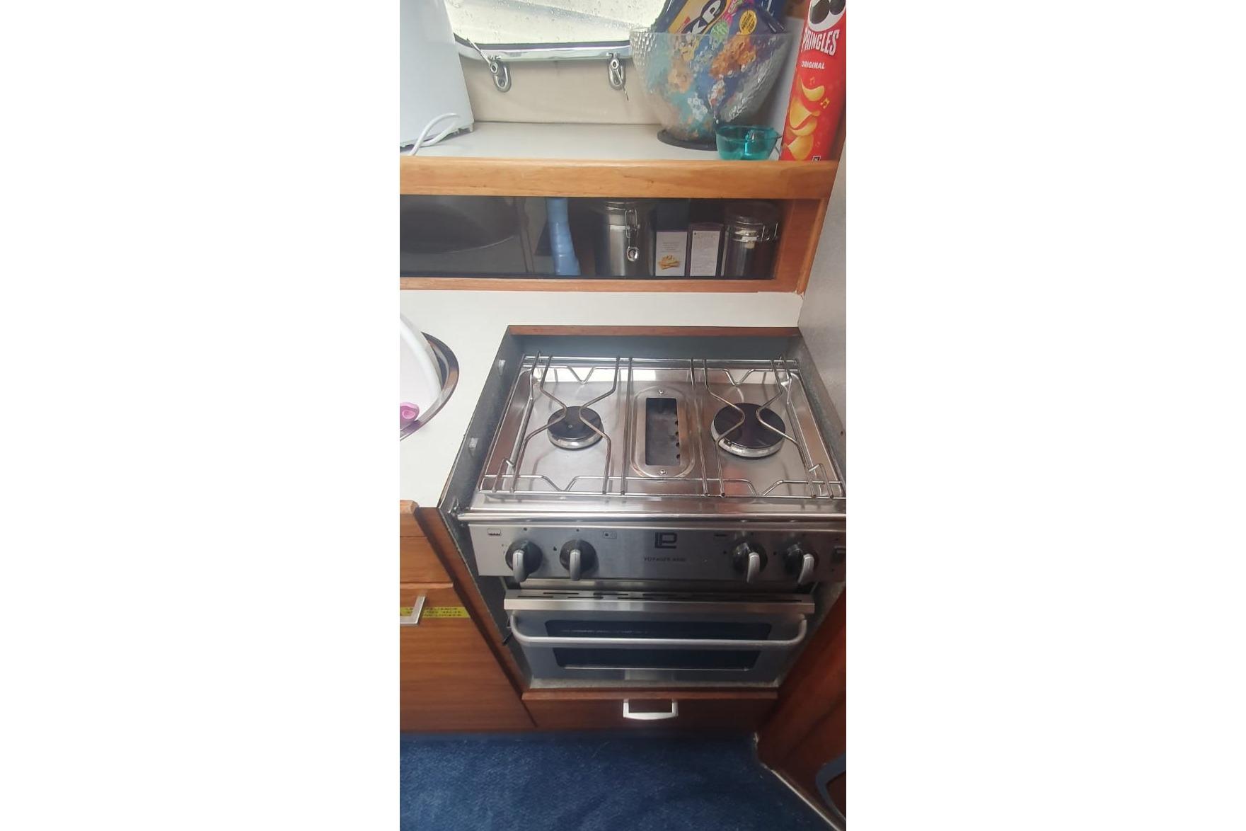 Compact kitchen area in 1989 Princess 35 boat with stove and storage.