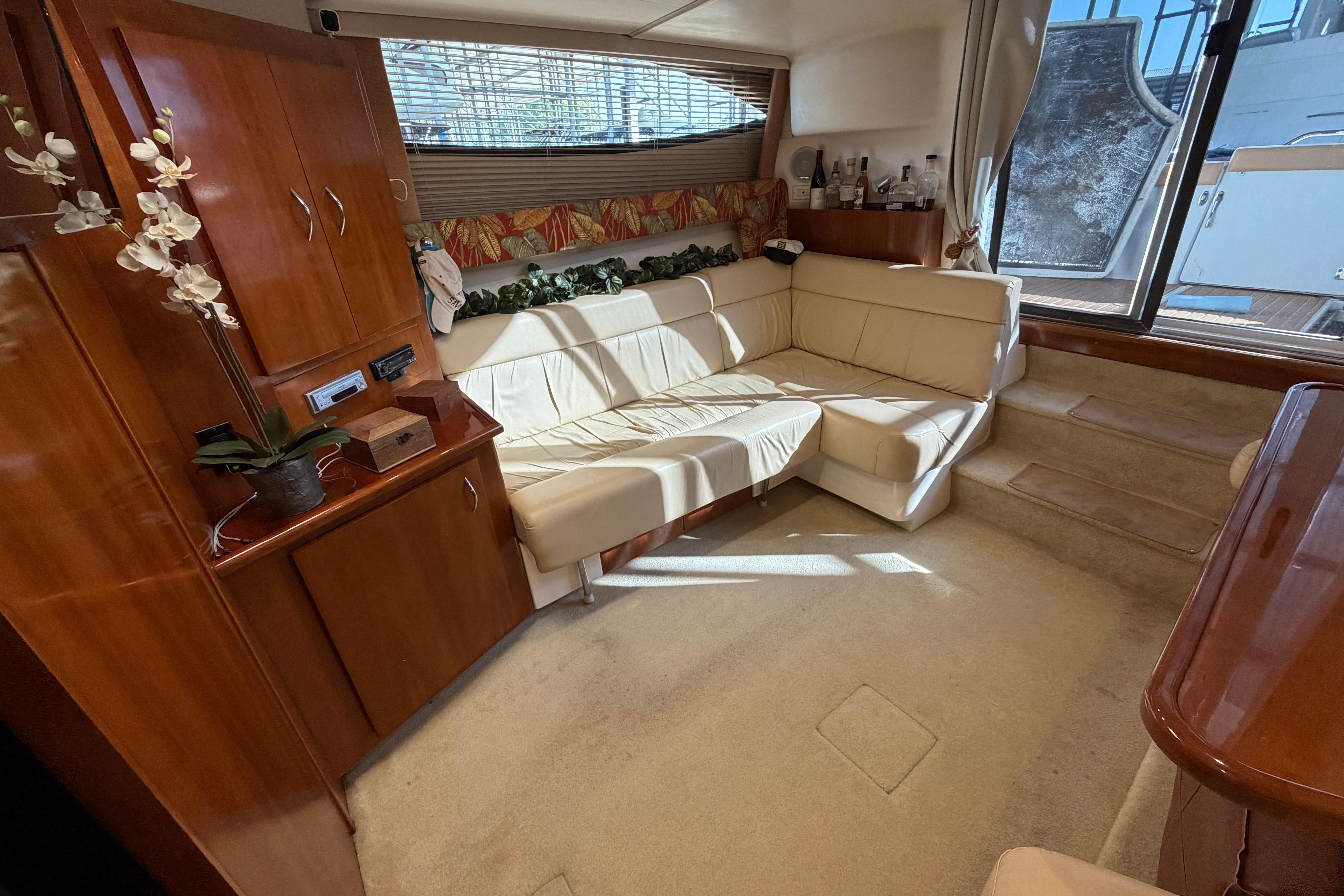 Luxurious interior of a 2003 Carver 350 Mariner yacht with elegant seating and wooden cabinetry.