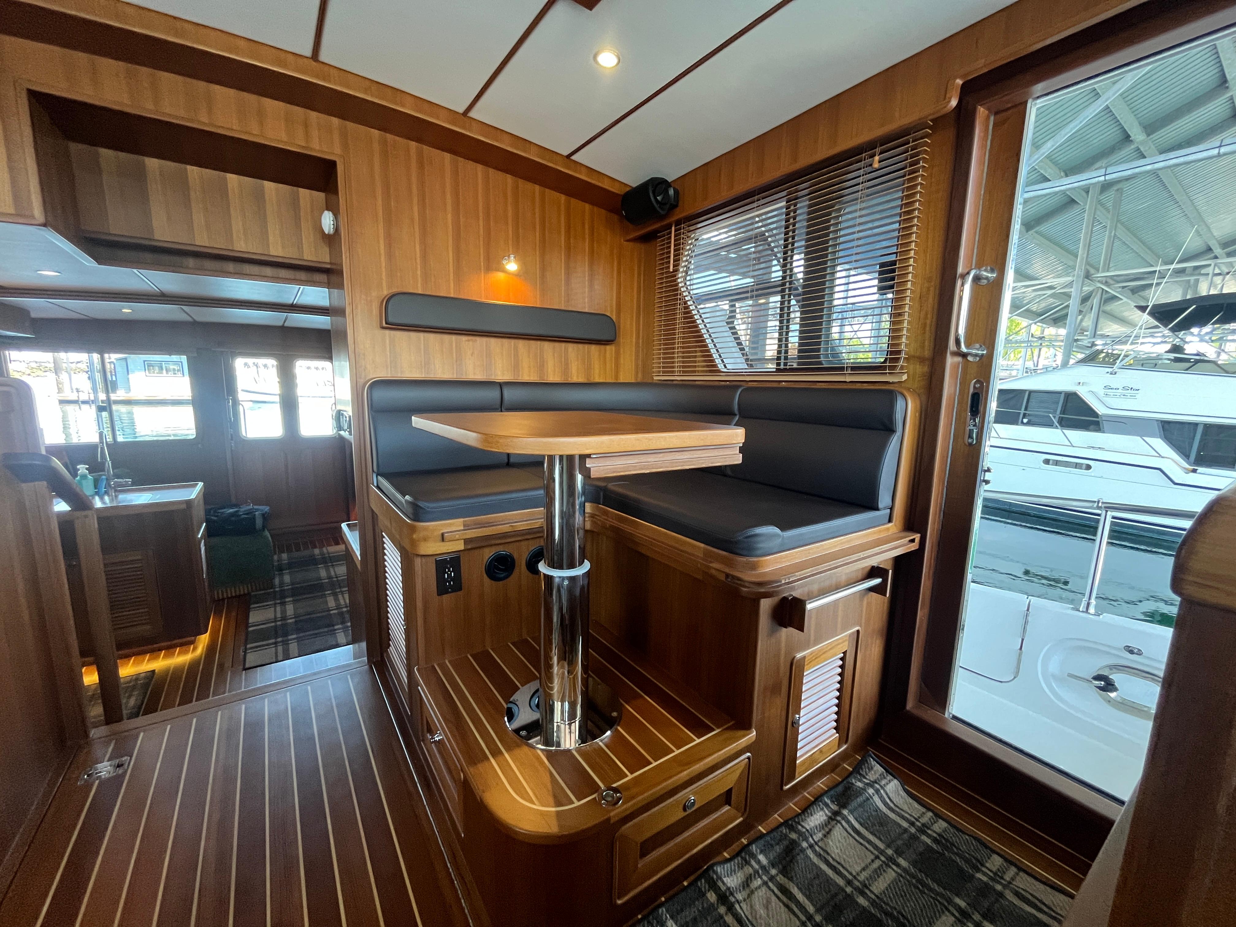 Luxurious 2025 Helmsman Trawlers 43E PILOTHOUSE interior with wood finish and seating area.
