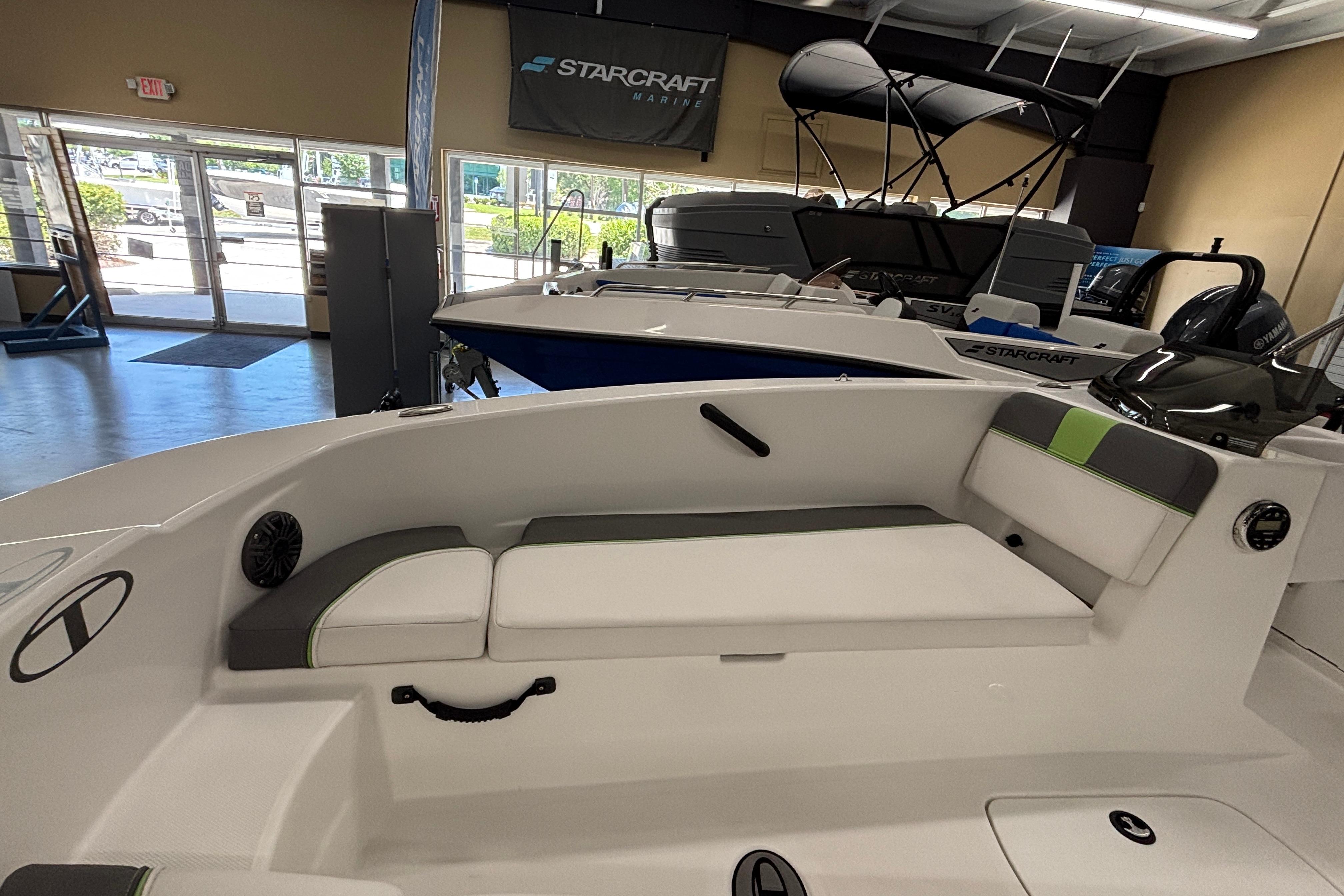 2024 Tahoe T18 boat interior with cushioned seating in a showroom.
