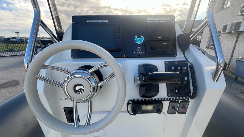 2023 Capelli Tempest 700 boat dashboard with steering wheel and control panel.