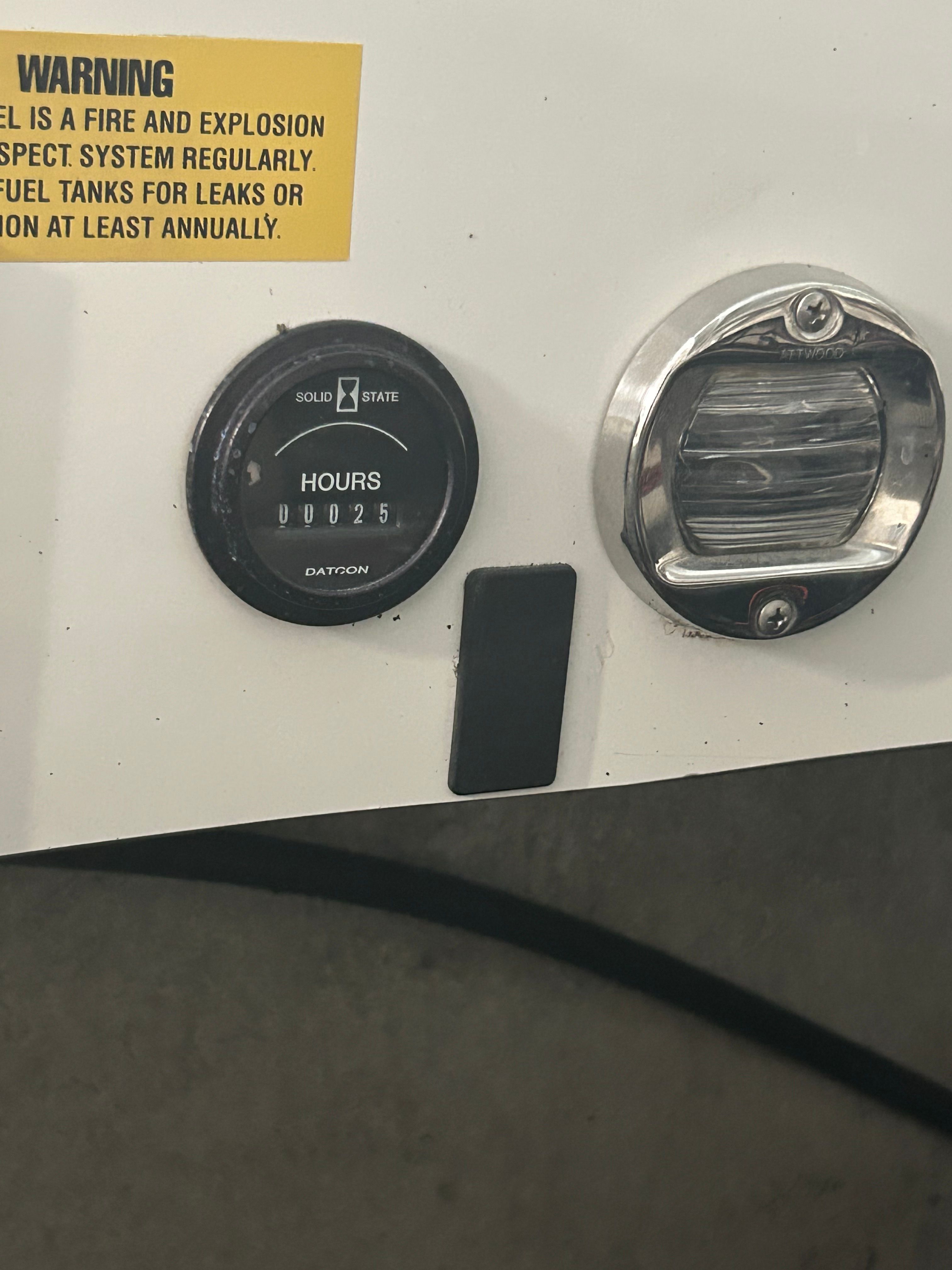 Close-up of an hour meter and a light on a boat.