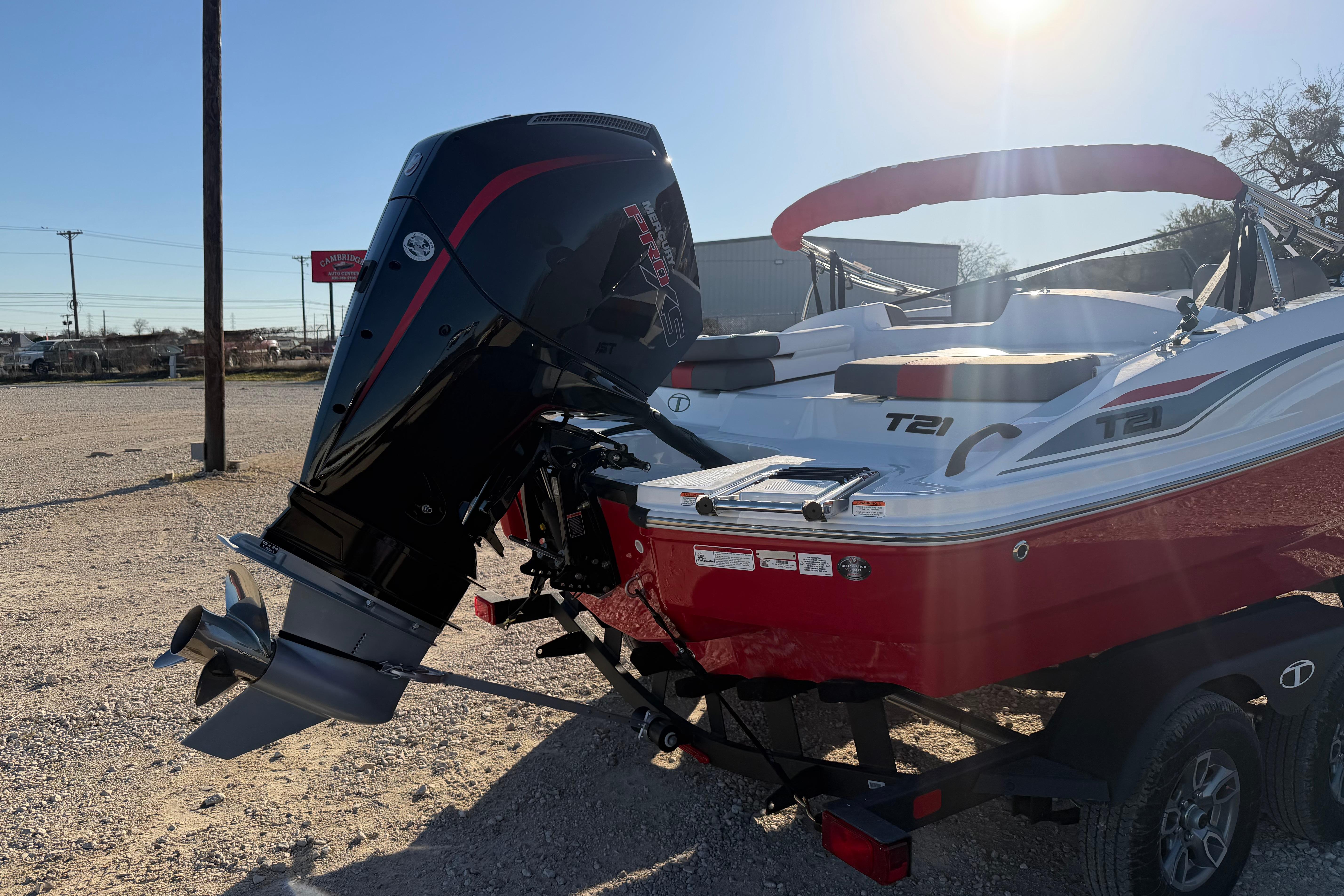 2026 Tahoe T21 boat with powerful outboard motor, parked on a trailer in sunlight.