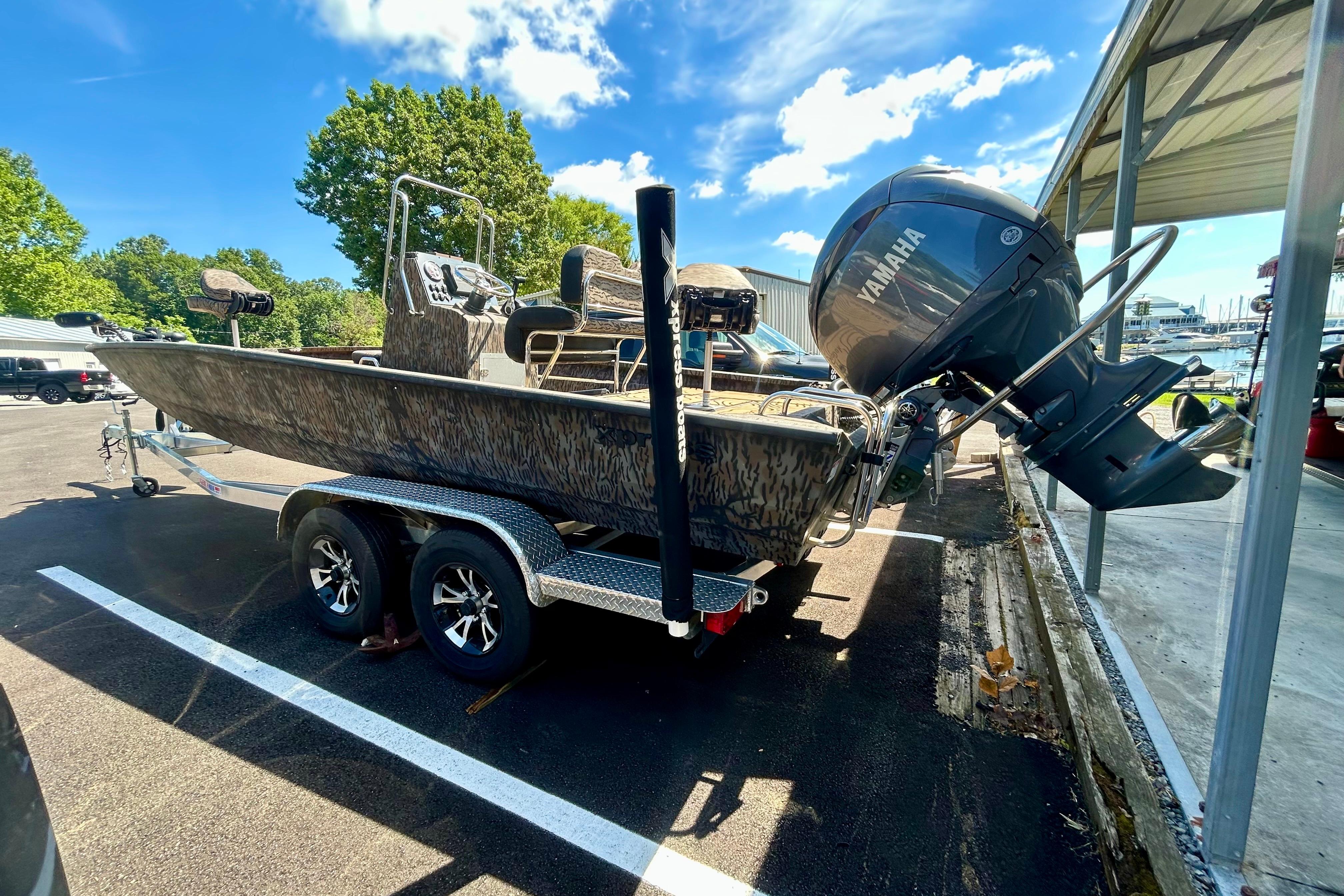 2025 Xpress H22B Bay boat with Yamaha engine on trailer, parked outdoors.