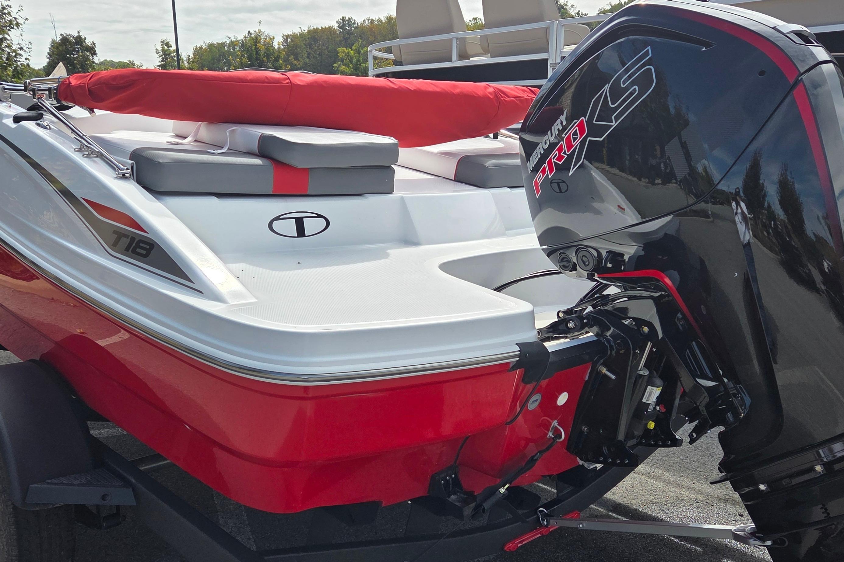 2026 Tahoe T18 boat with Mercury Pro XS engine, red and white design, parked outdoors.