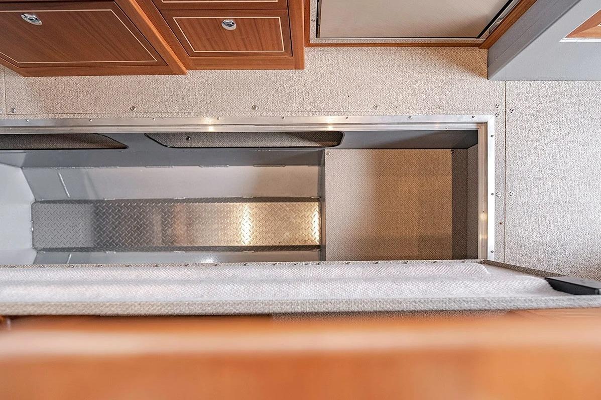 Interior view of 2026 KingFisher 3225 GFX Offshore boat, featuring storage compartment and cabinetry.