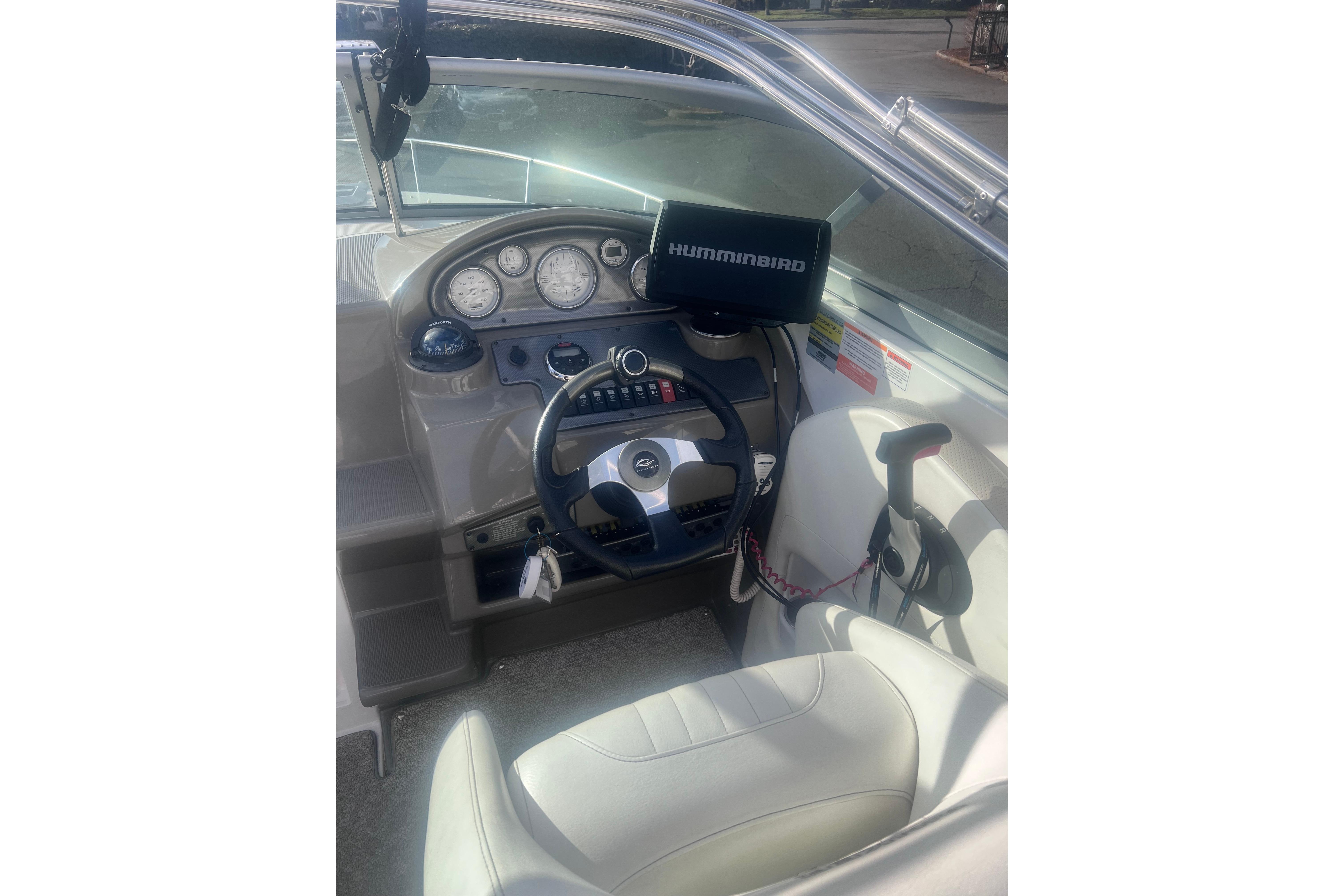 2007 Rinker 230 Captiva Atlantic boat dashboard with steering wheel and Humminbird device.