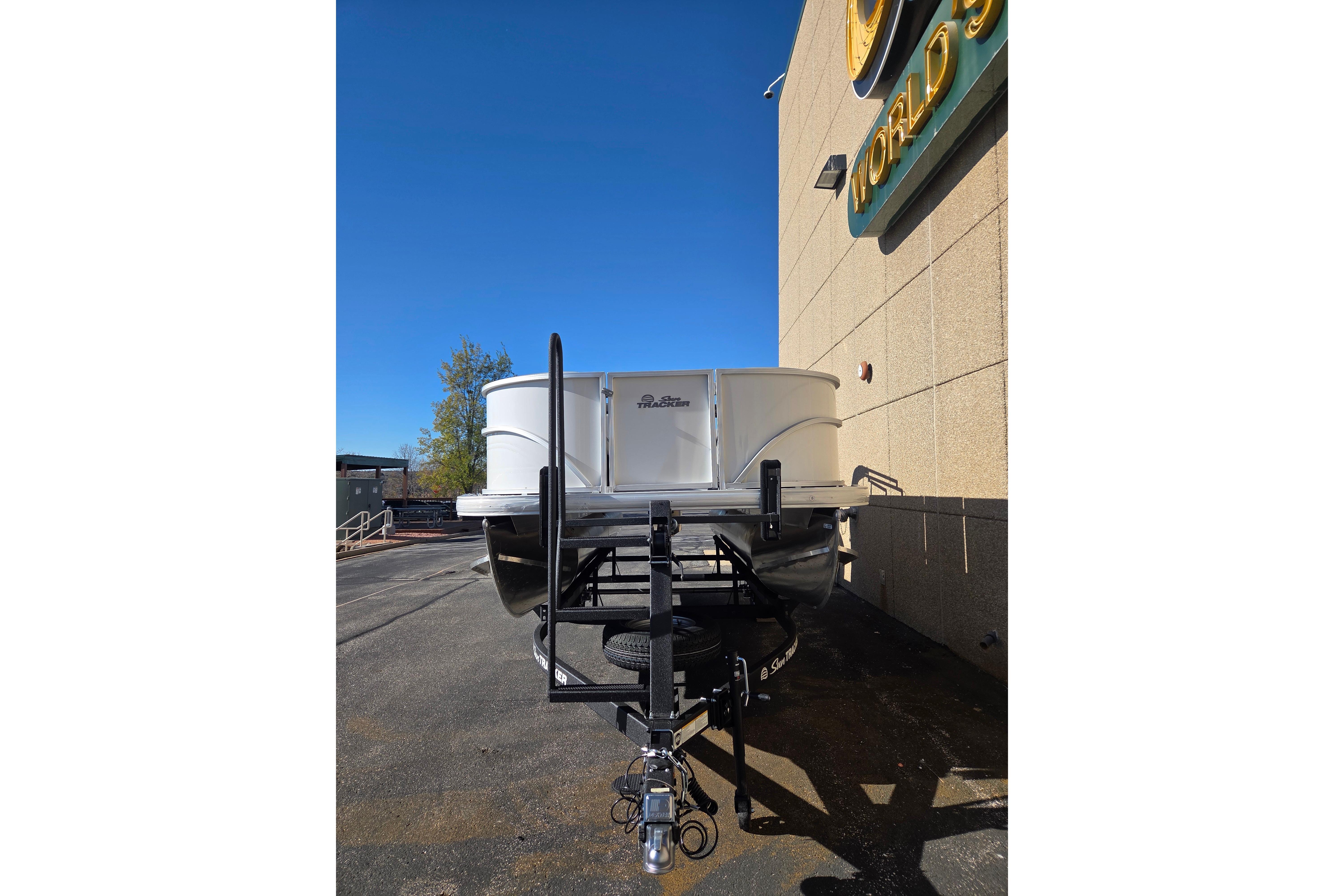 2026 Sun Tracker Party Barge 18 DLX pontoon boat on trailer, parked outdoors.