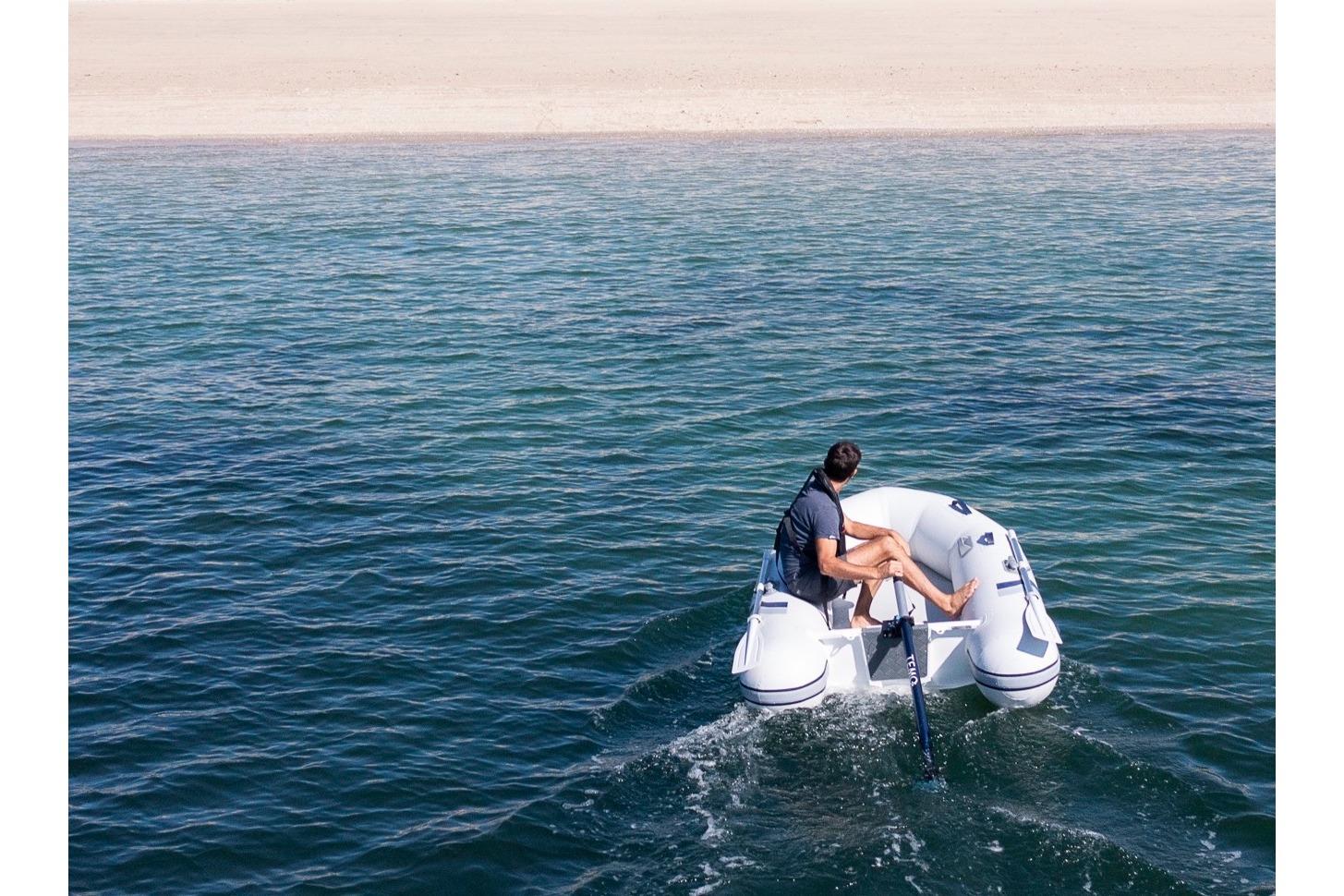 Person operating Highfield Roll-Up 250 KAL boat on open water.