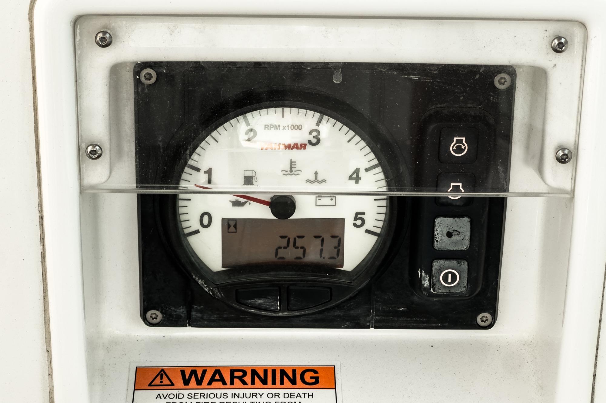 Close-up of a 2017 Beneteau Sense 50 engine gauge displaying RPM and warning label.
