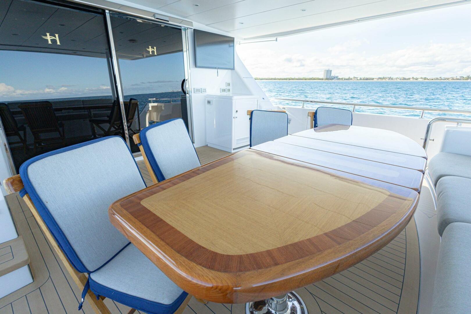 Luxurious 2009 Hargrave Enclosed Bridge yacht deck with elegant dining area and ocean view.