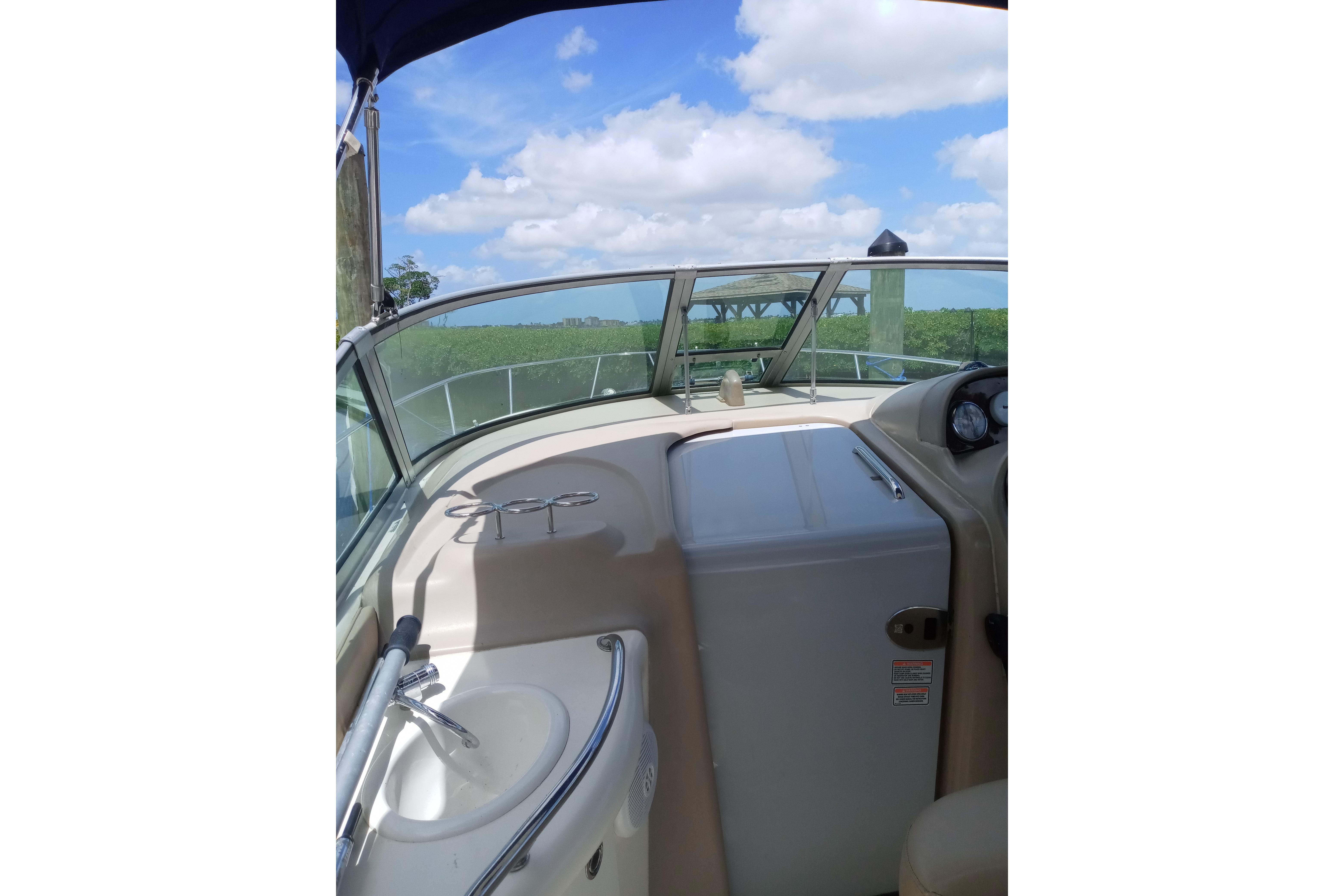 2005 Sea Ray 300 Sundancer boat interior with sink and clear sky view.