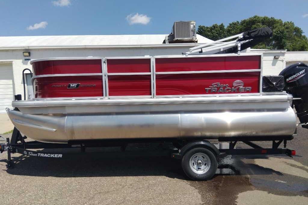 2026 Sun Tracker Party Barge 16 DLX pontoon boat on trailer, red and silver design.