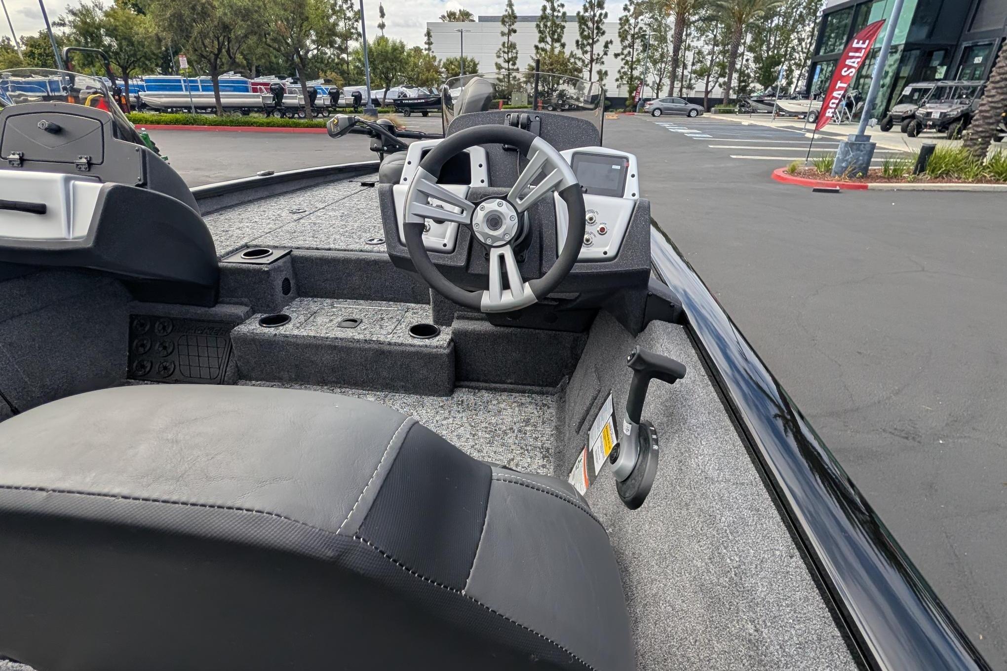 2026 Tracker Pro Team 195 boat interior with steering wheel and dashboard in parking lot.