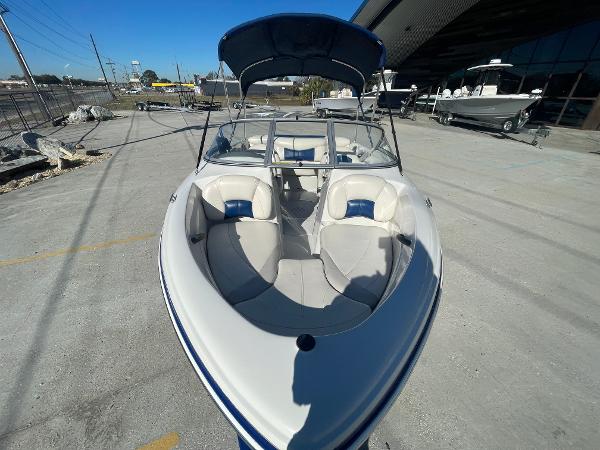 2012 Tahoe Q4 SS boat with open bow seating, parked outdoors.