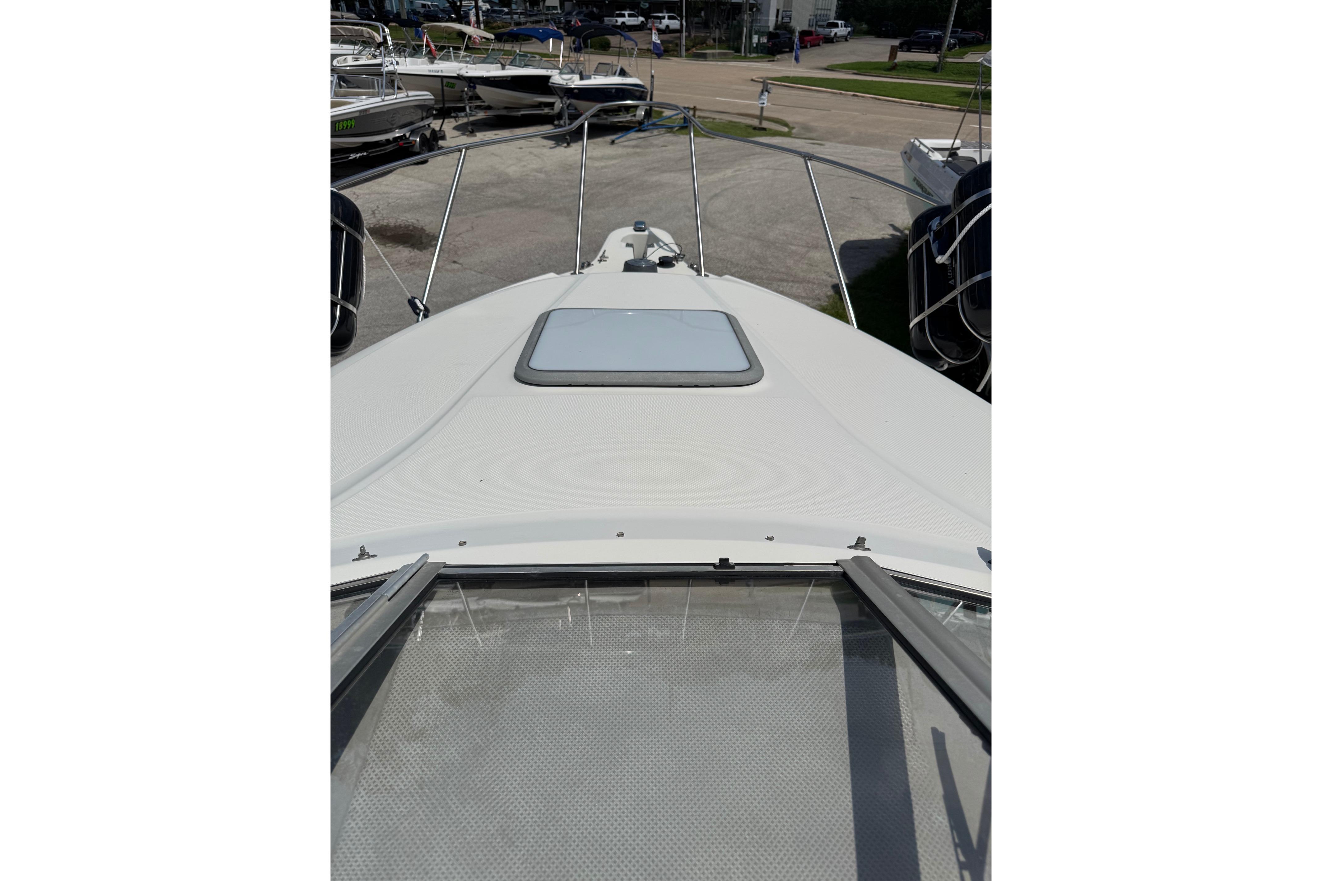 2000 Maxum 2400 SCR boat deck view with open hatch and railing.