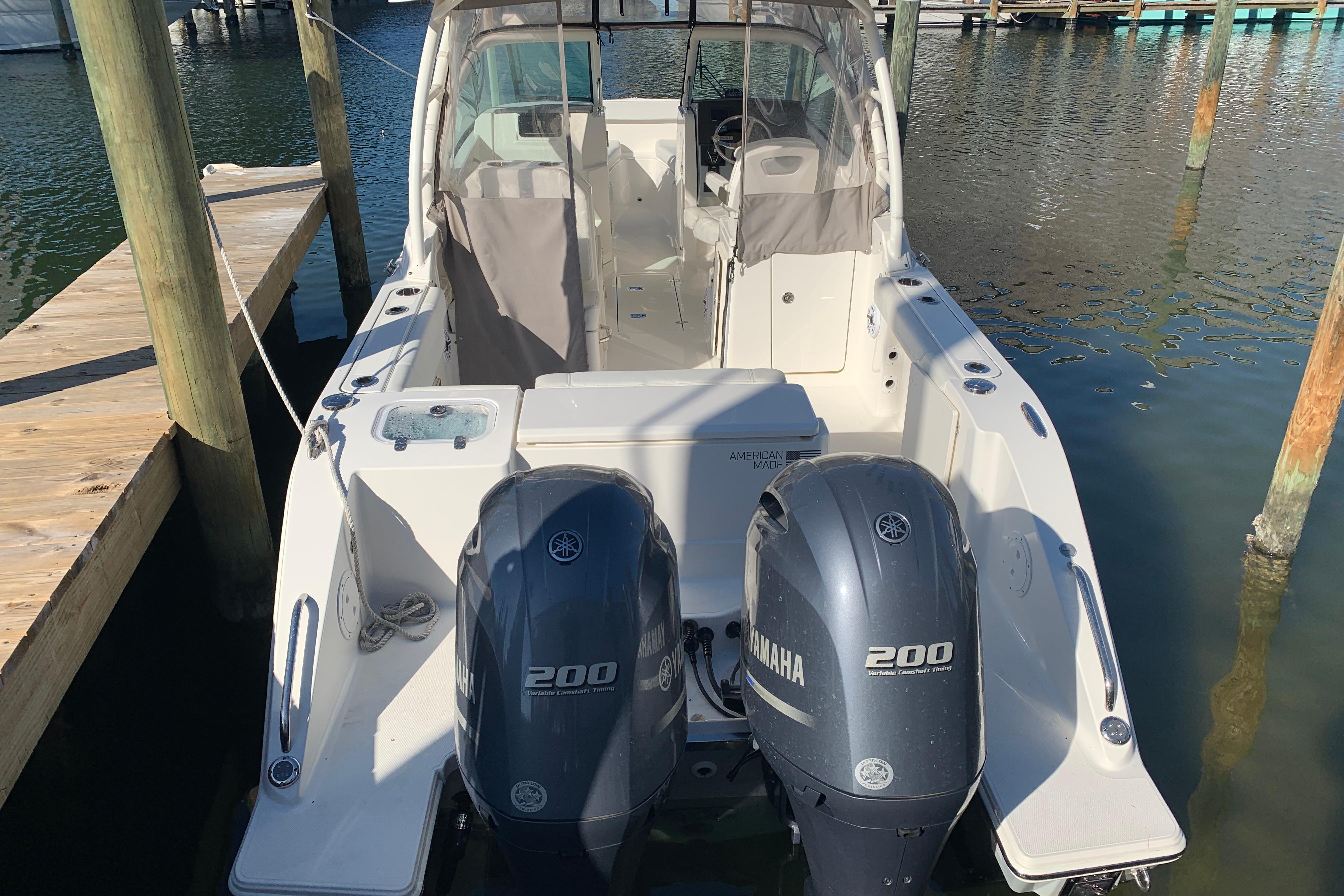 2023 Pursuit DC 266 Dual Console boat with twin Yamaha 200 engines docked.