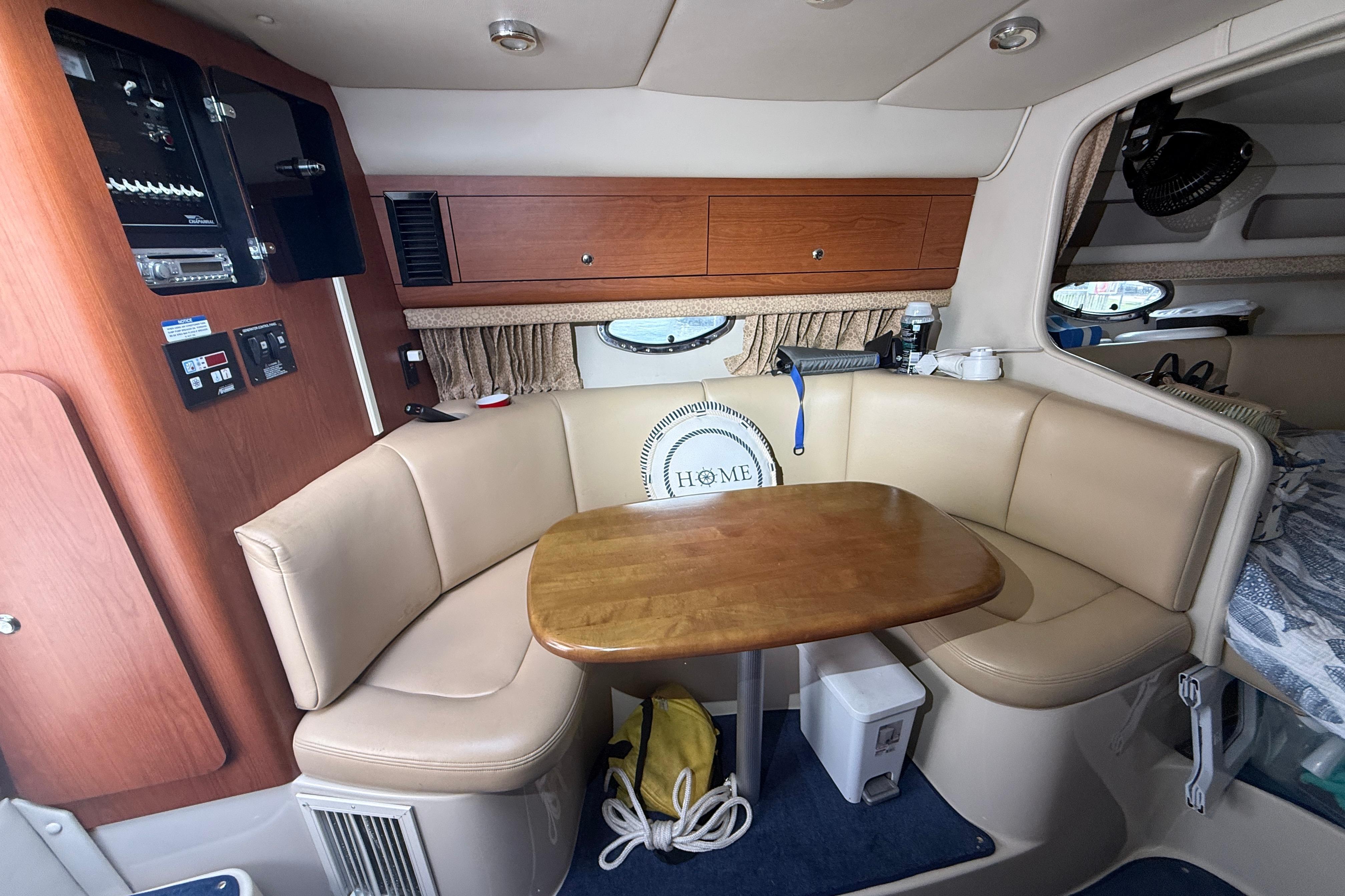 Interior of 2003 Chaparral Signature 280 boat with cozy seating and wooden table.