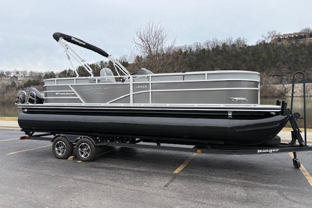 2025 Ranger Reata 243C pontoon boat on trailer in parking lot.