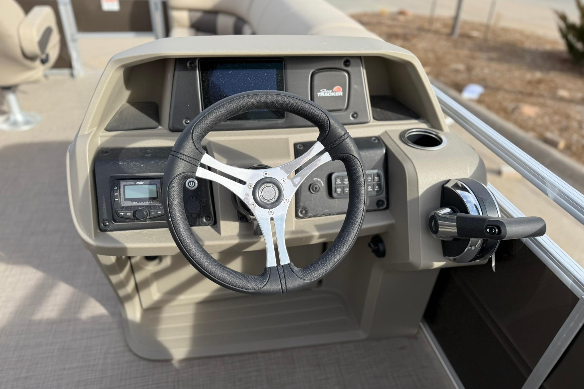 2025 Sun Tracker SportFish 20 DLX boat dashboard with steering wheel and controls.