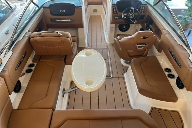 2025 Chaparral 247 SSX boat interior with brown seating and white table.
