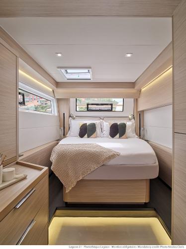Luxurious interior of 2025 Lagoon 51 ICONIC yacht with cozy bedroom and modern design.