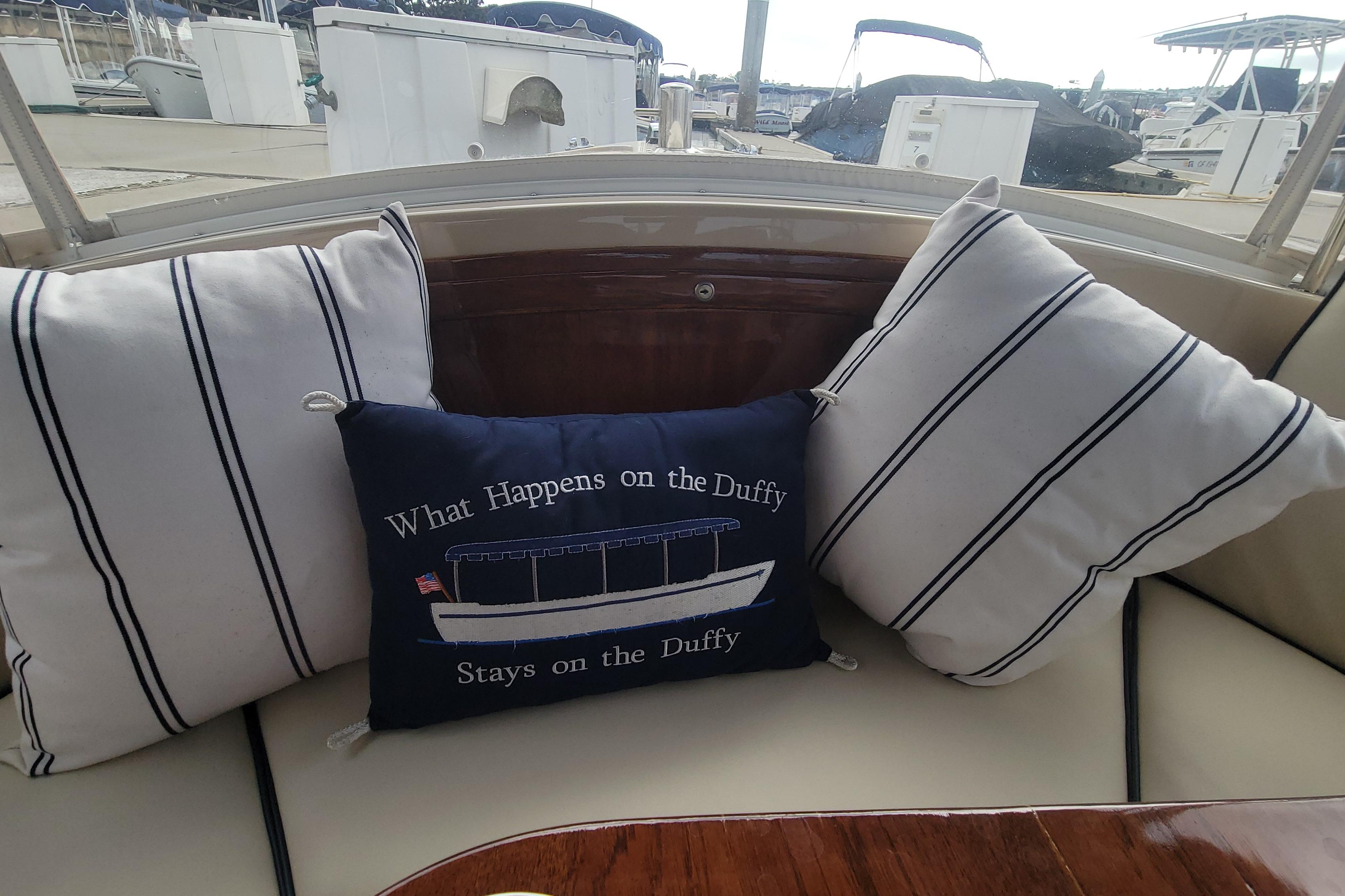 Cozy seating on 2008 Duffy Snug Harbor 18 with nautical-themed pillows.