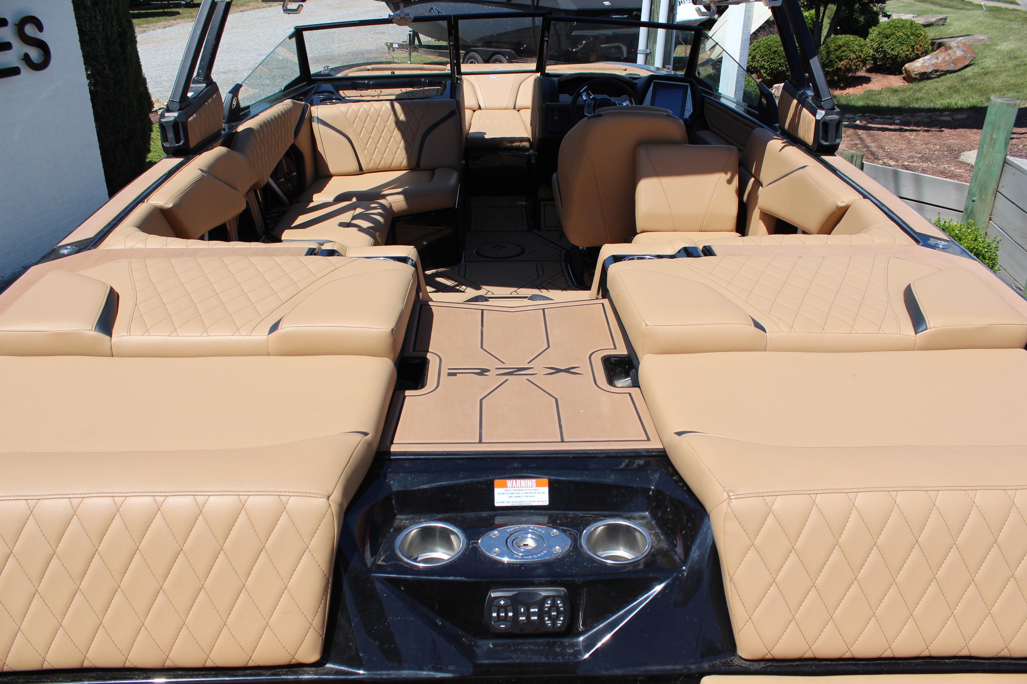 2022 Tigé 22RZX boat interior with tan quilted seating and modern dashboard.