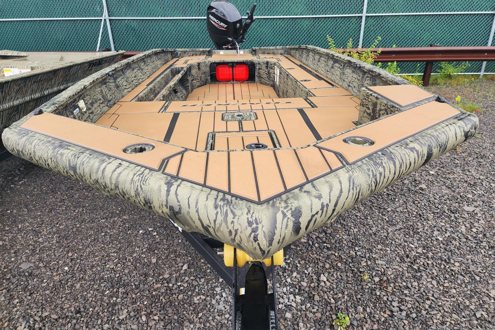 2026 Tracker Grizzly 1756 T Marsh boat with camouflage design on gravel surface.