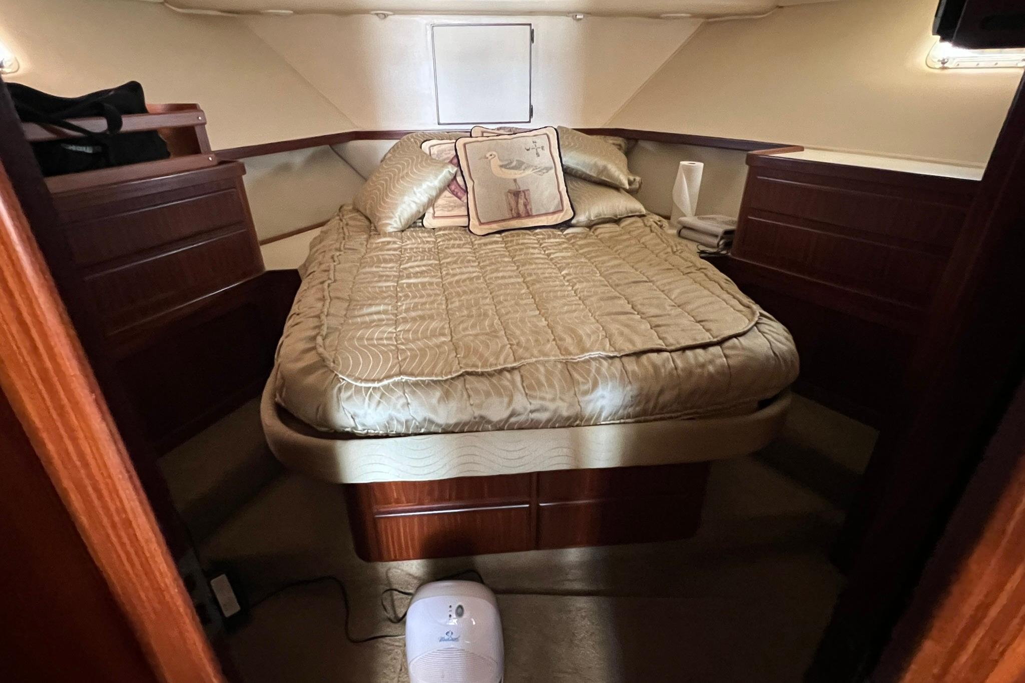 Cozy cabin interior of 1990 Hatteras 41 Convertible yacht with elegant bedding.