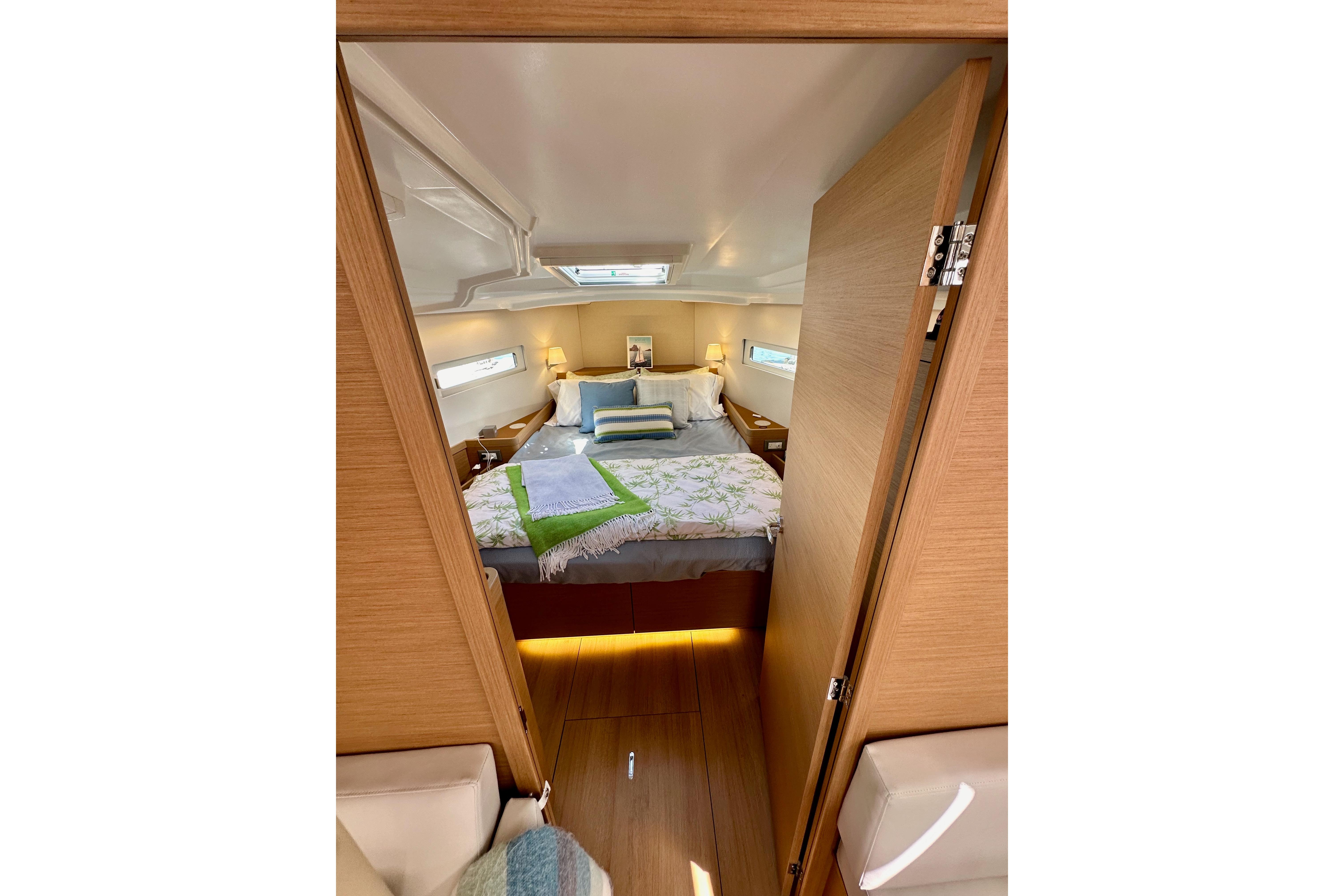 Cozy cabin interior of 2024 Jeanneau Sun Odyssey 410 sailboat, featuring a comfortable bed.