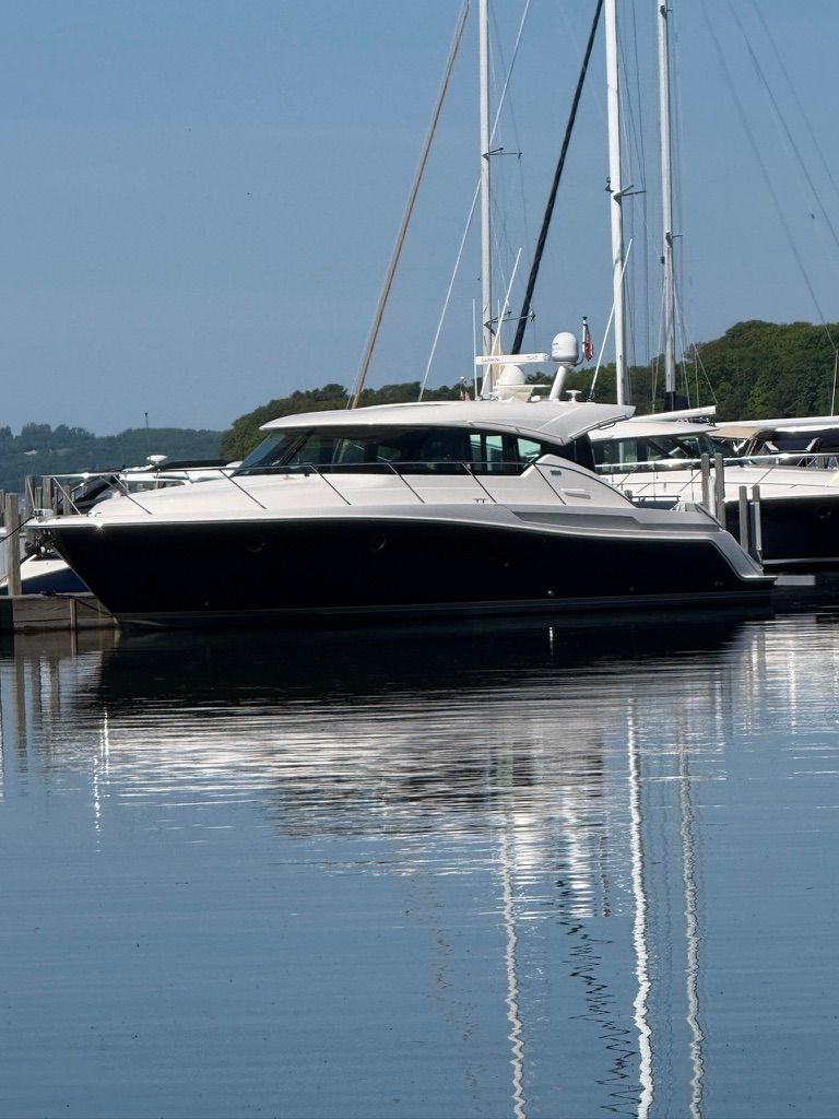 A 2017 Tiara Yachts C44 Coupe is docked calmly on the water.
