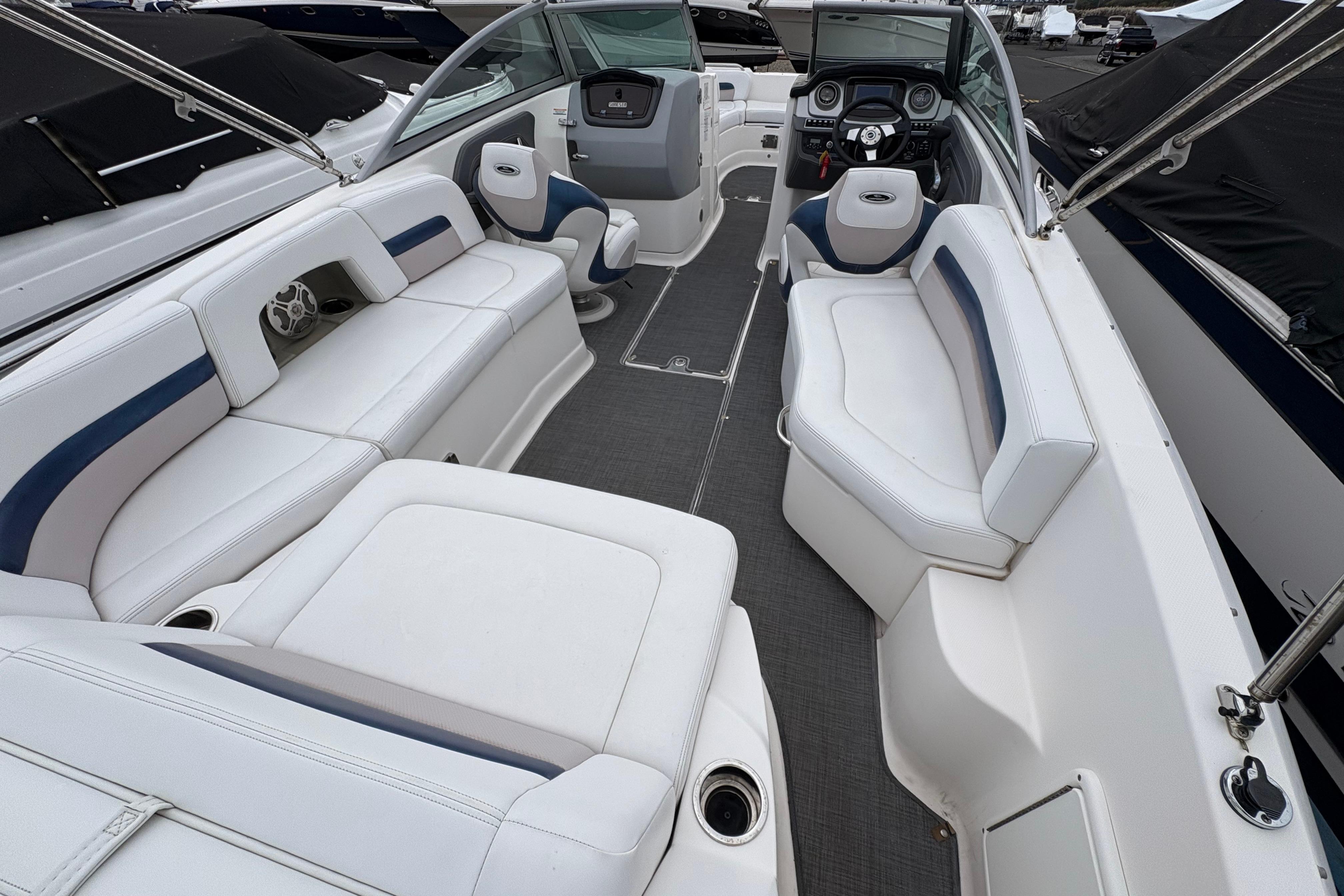 2015 Chaparral 264 Sunesta boat interior with white seating and modern dashboard.