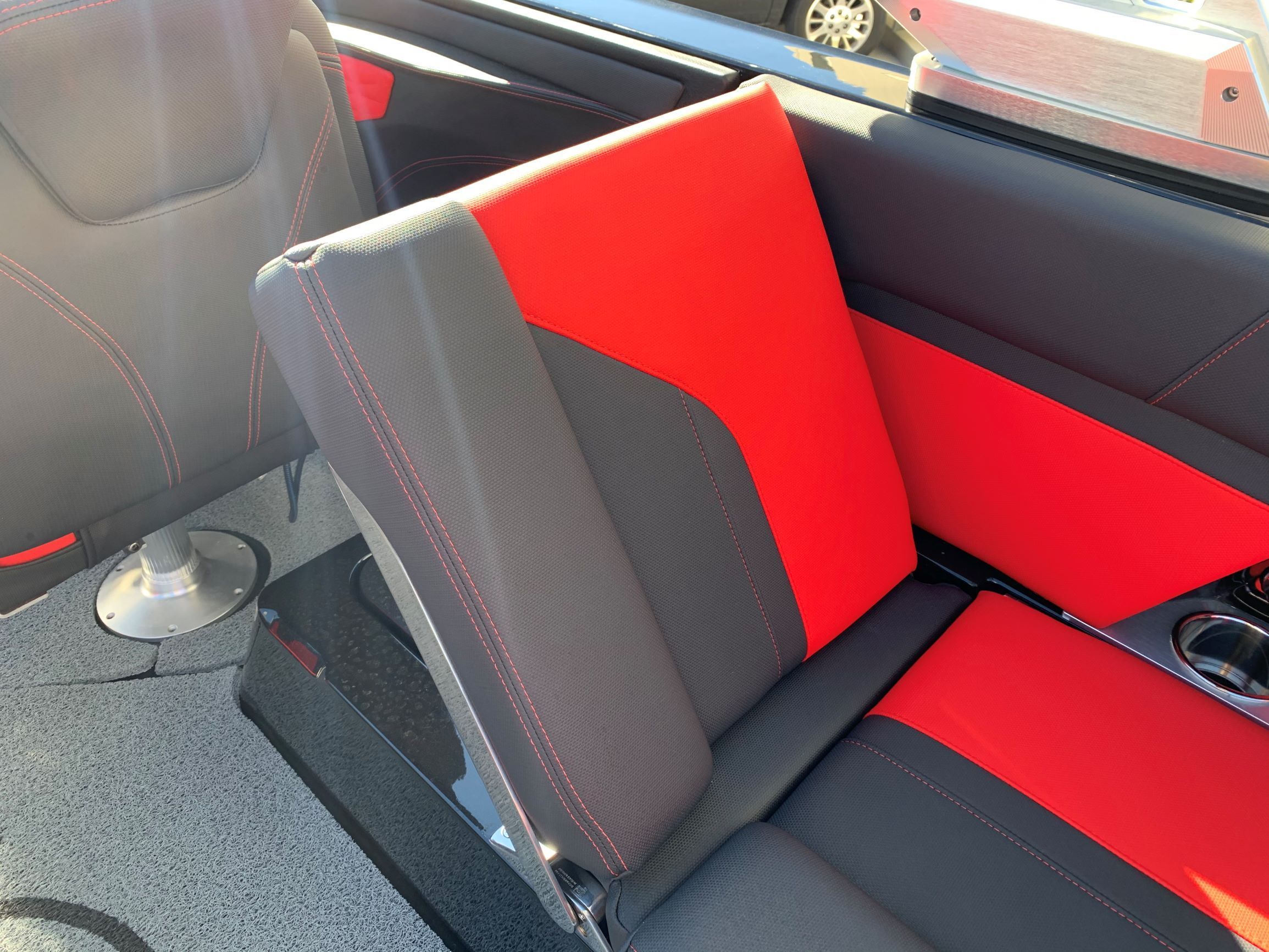 Red and gray seating inside a boat with cup holders.