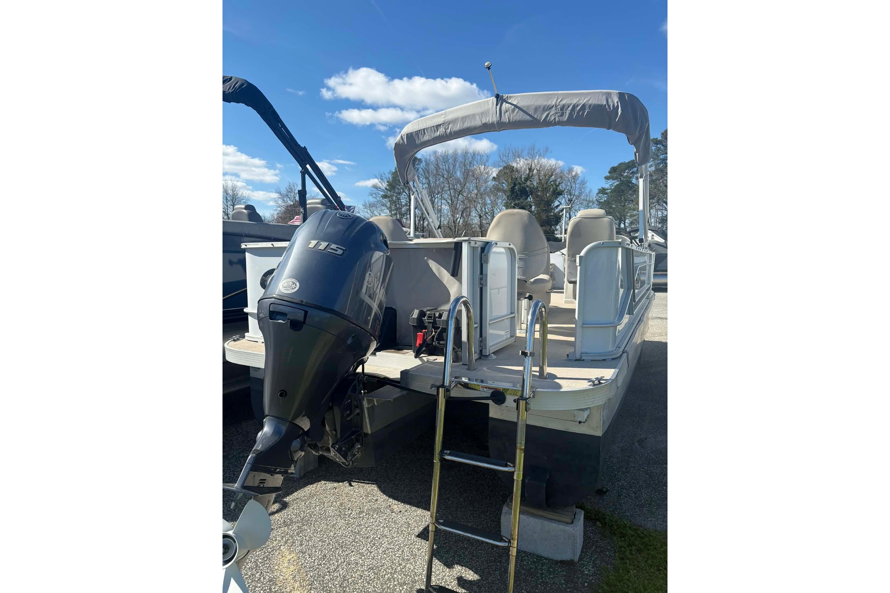 2017 G3 boat with outboard motor and canopy, parked outdoors under blue sky.