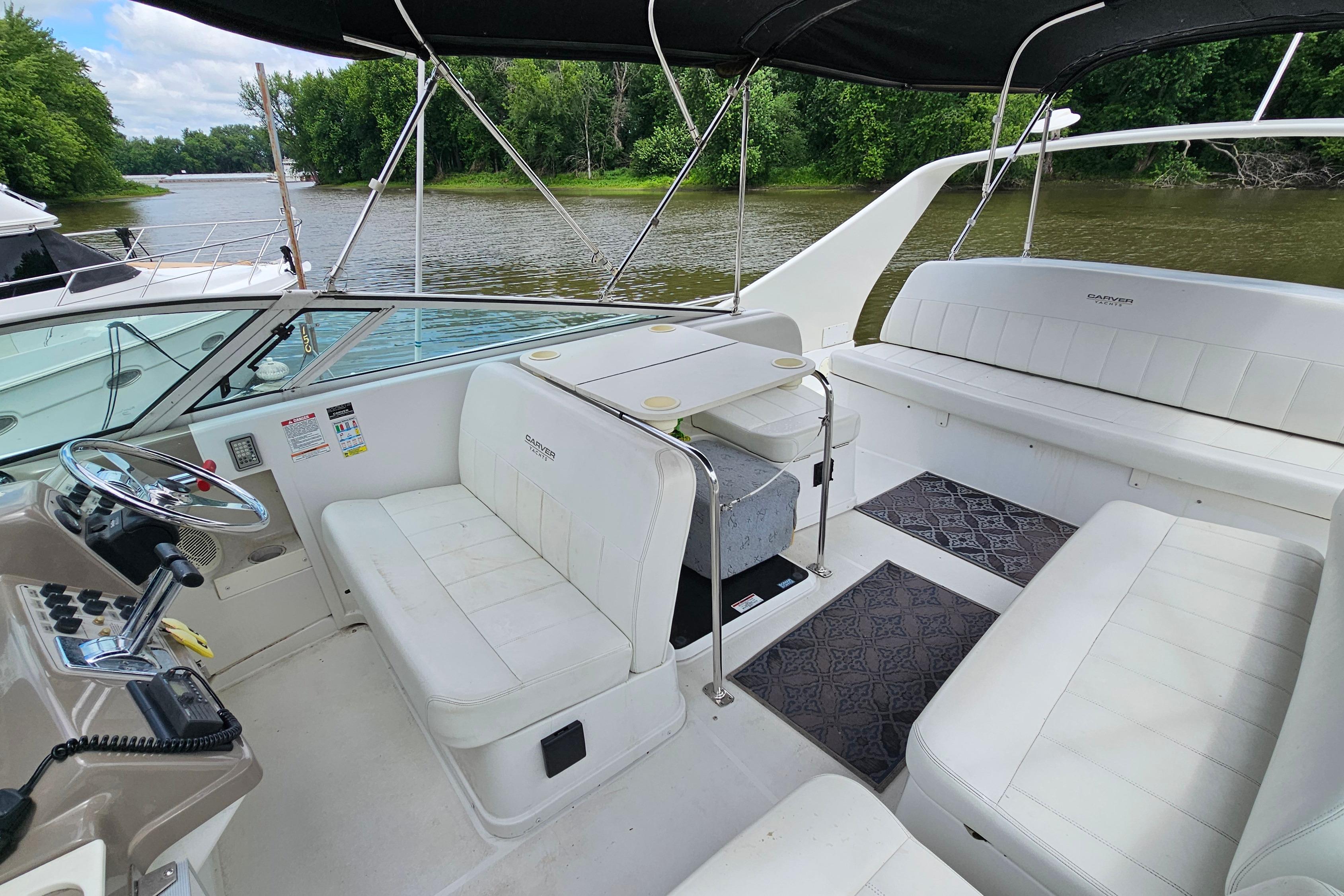 1999 Carver 350 Mariner boat interior with white seating, steering wheel, and river view.