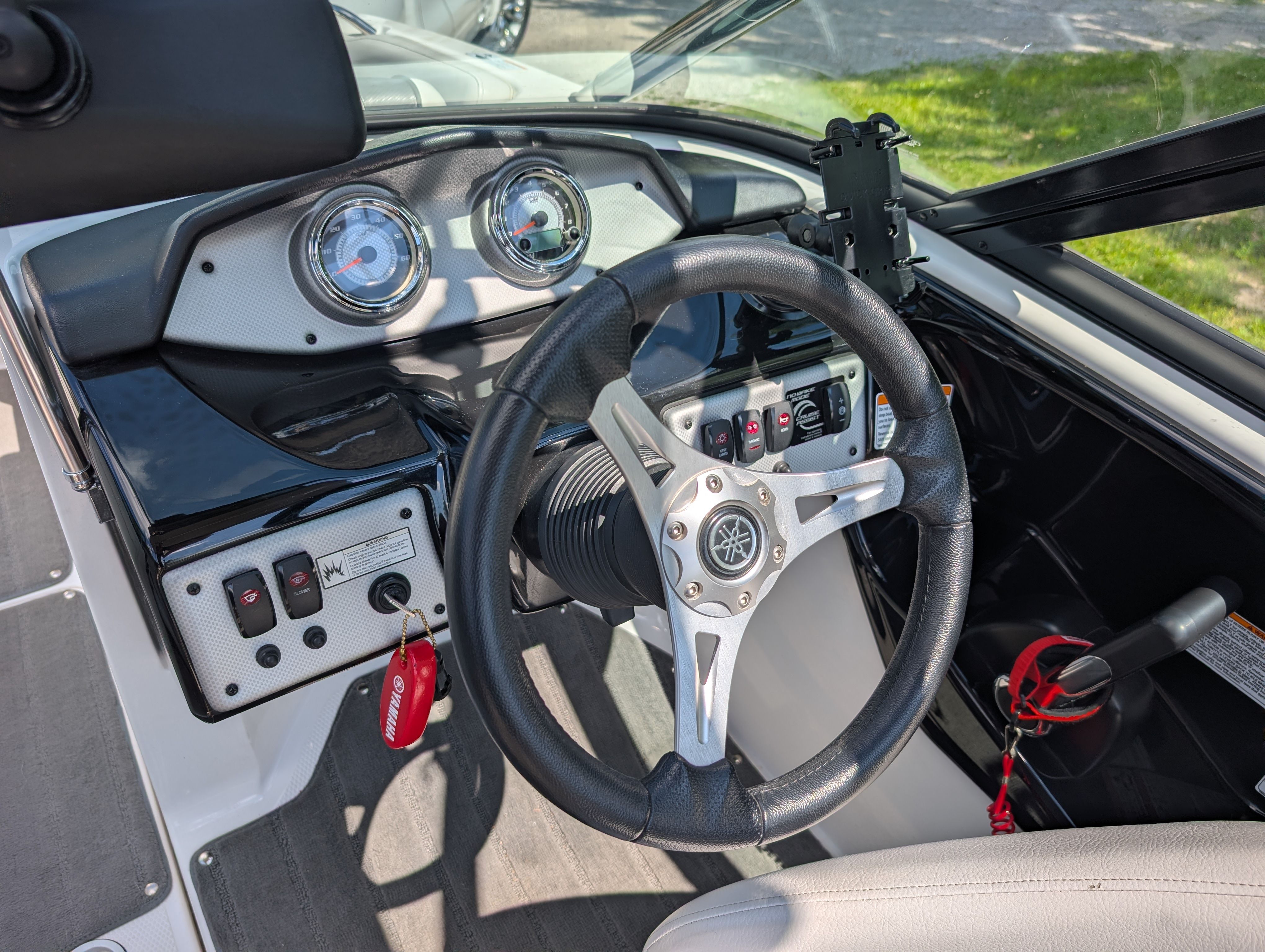 The image shows the cockpit of a 2014 Yamaha AR192 boat with a modern steering wheel and instruments.