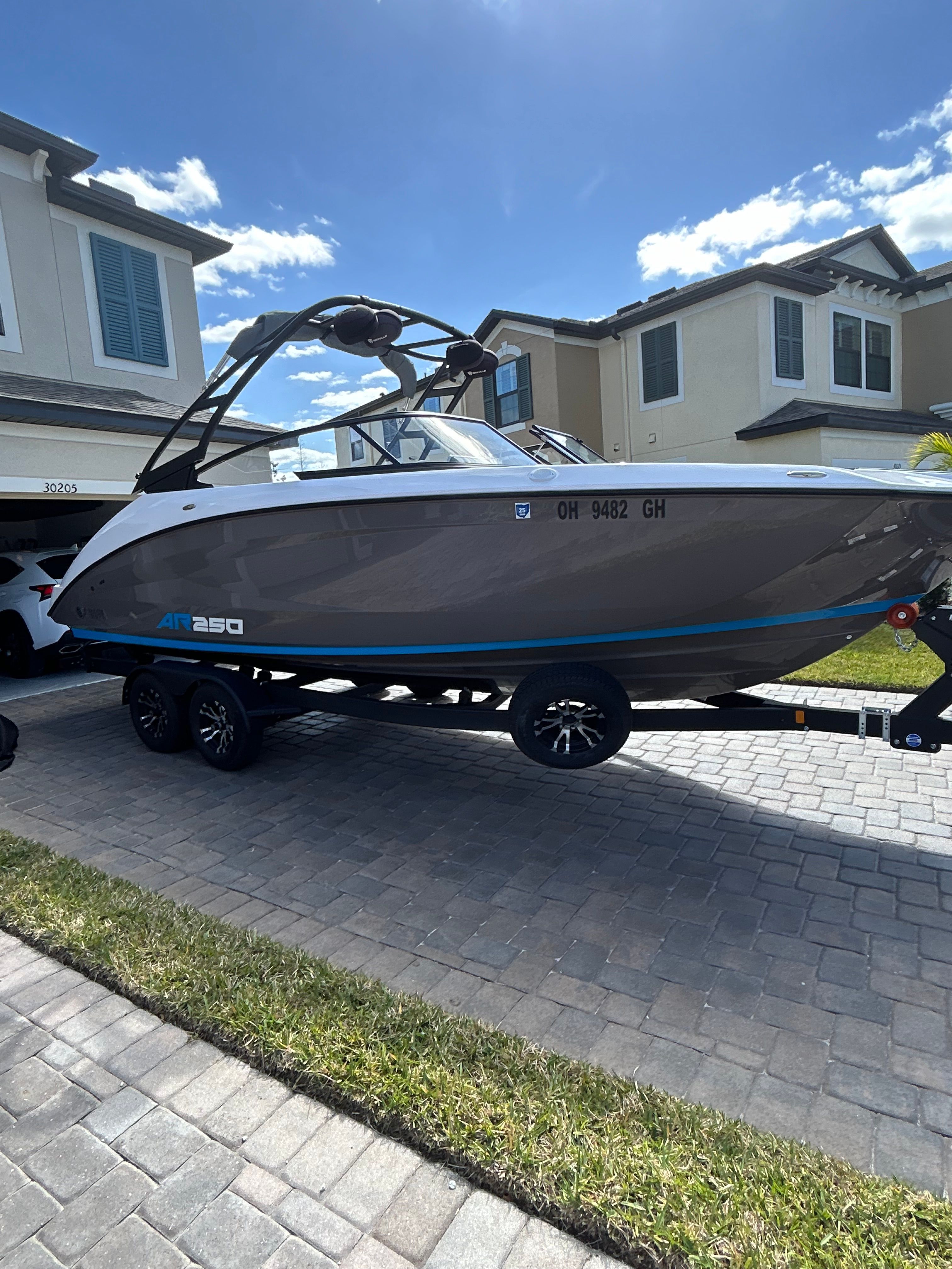 A 2022 Yamaha AR250 boat on a trailer in a residential area.