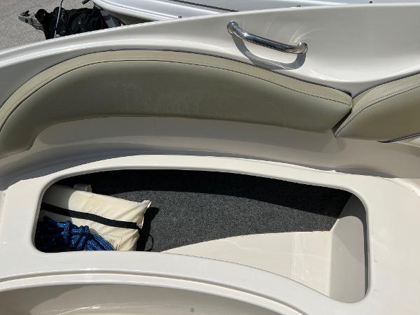 2005 Sea Ray 220 Sundeck interior storage compartment with cushioned seating and handle.