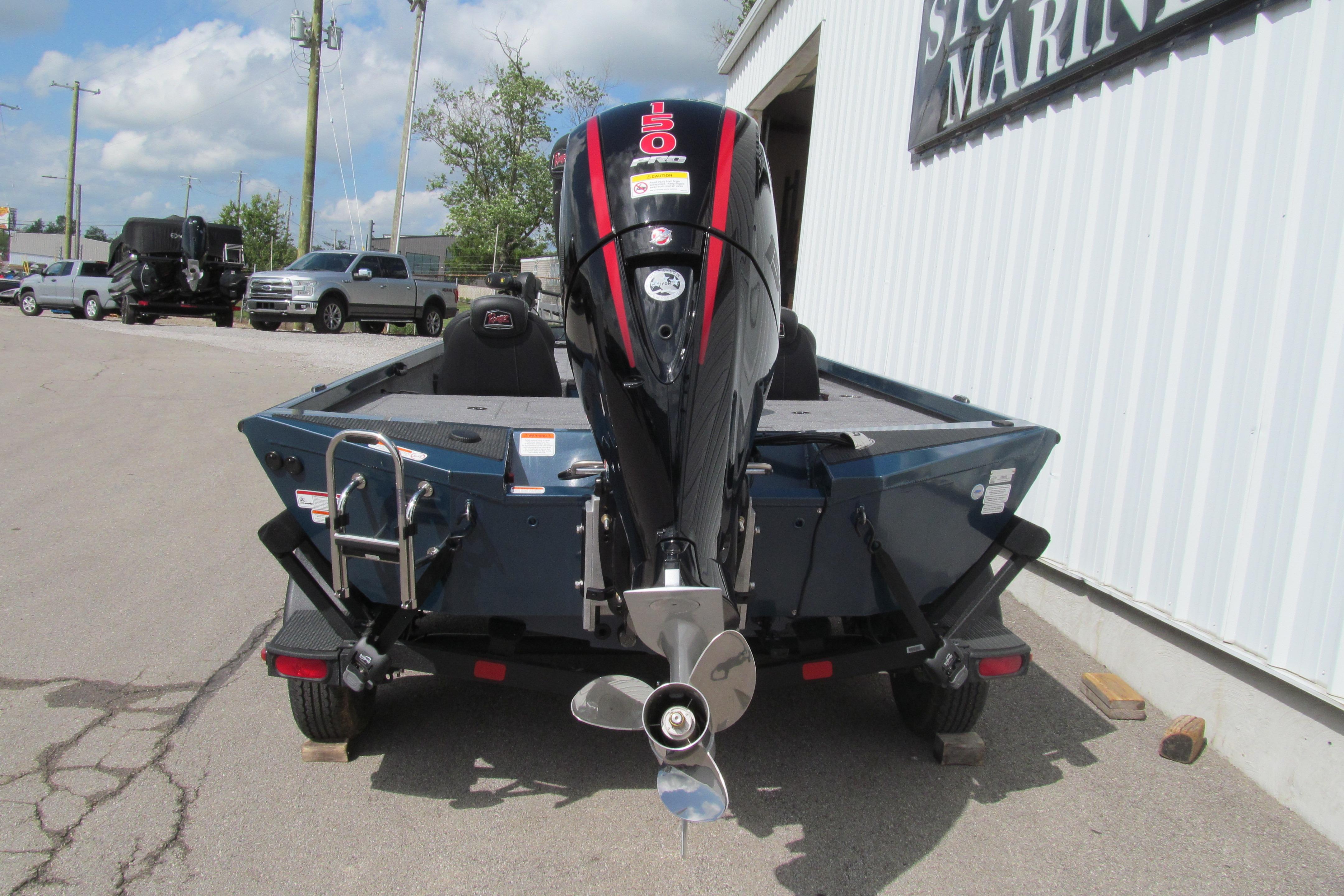 2026 Ranger RT198P boat with powerful outboard motor, parked near a marine store.