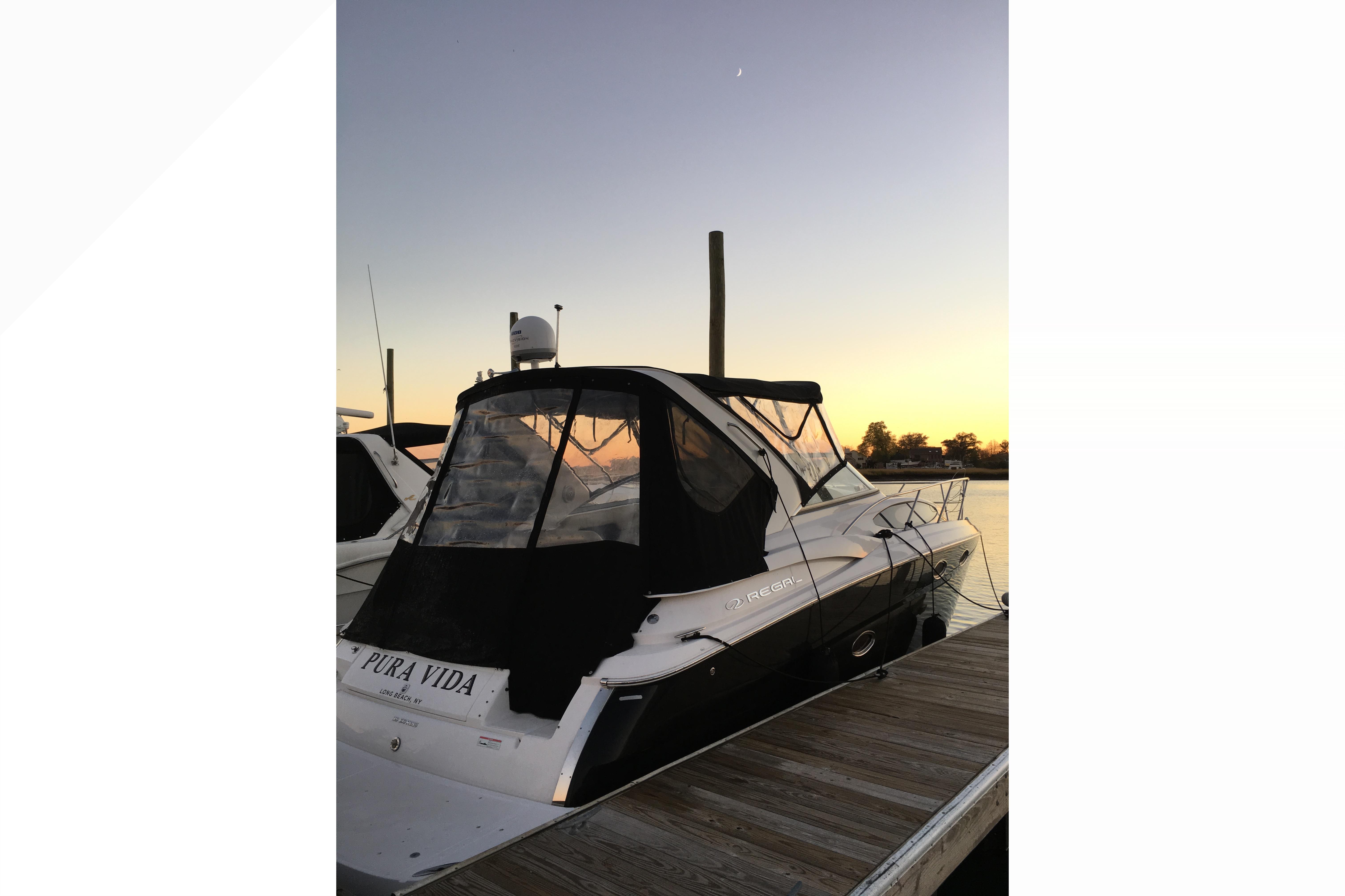 2012 Regal 35 Express Cruiser docked at sunset, rear view.